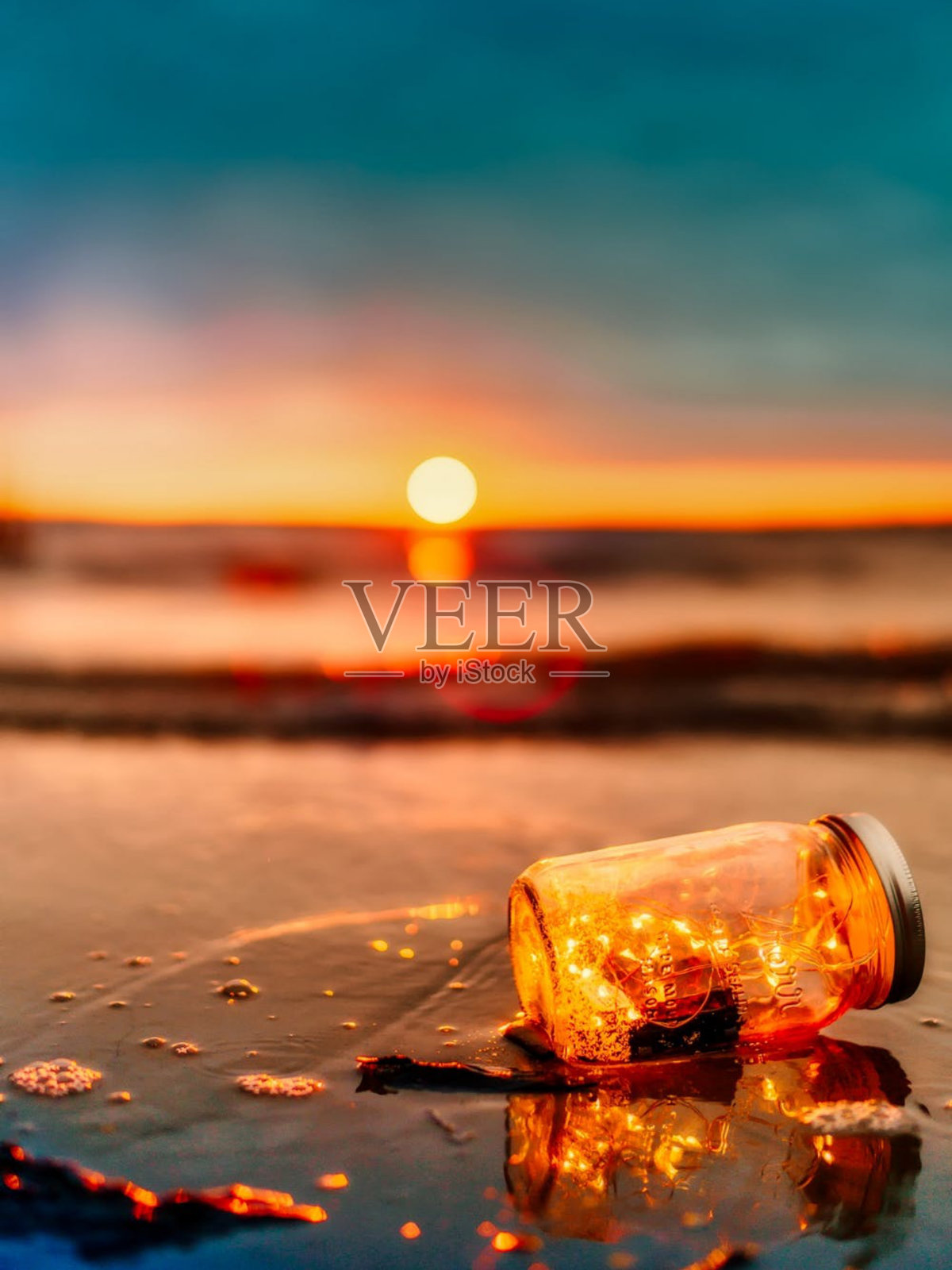 大海东边有美丽的太阳，海边有许多装在玻璃瓶里的吊灯。美丽的景色。照片摄影图片