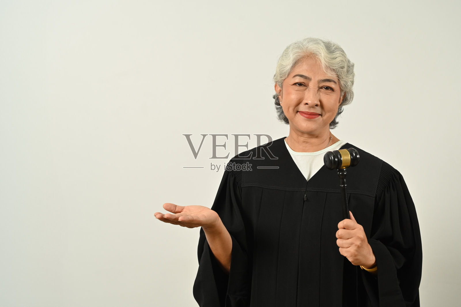 穿着法袍制服，手持木槌的中年女法官，与法律和正义概念相关的元素照片摄影图片