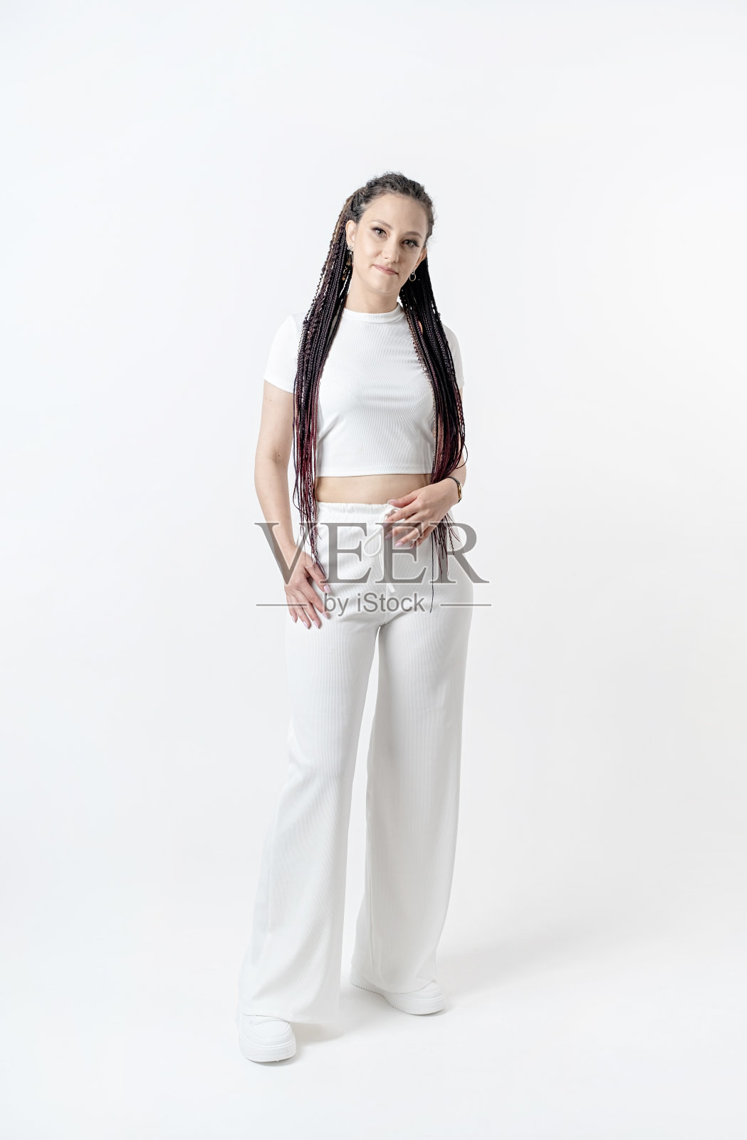 时尚的年轻美丽的女人与脏辫在白色背景下摆姿势照片摄影图片