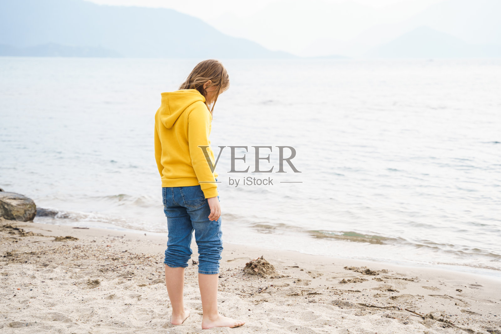 孤独、美丽、悲伤的少女沉思地坐在沙滩上。梦想，焦虑，对未来的担忧，学校朋友，父母。青少年欺凌，青春期心理问题照片摄影图片