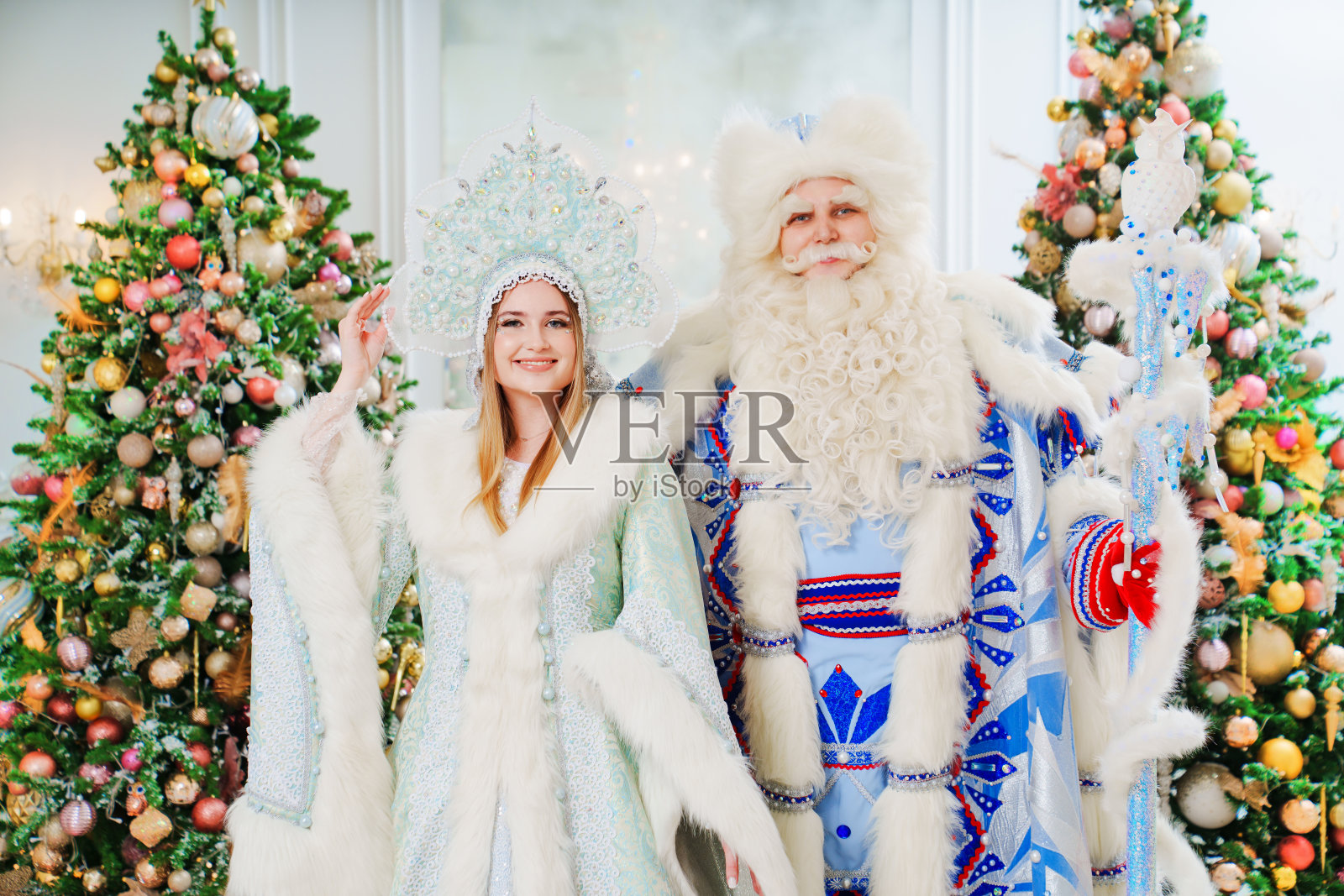 冰霜父亲和白雪公主穿着蓝色的服装，在房间里有圣诞树照片摄影图片