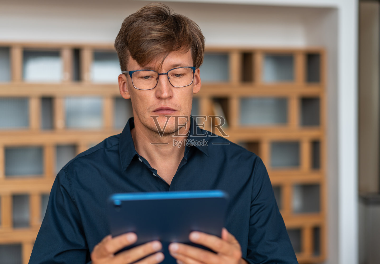拿着平板电脑的严肃的年轻商人照片摄影图片