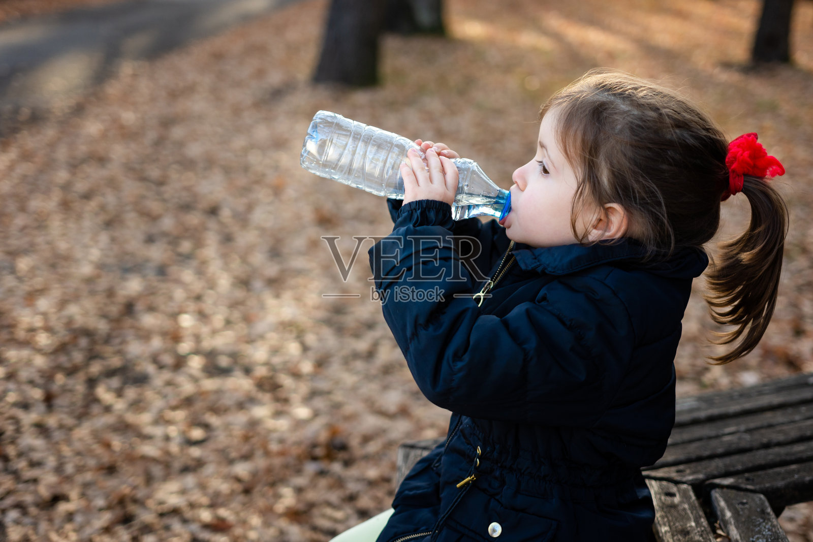 一个女孩在大自然中从瓶子里喝水照片摄影图片