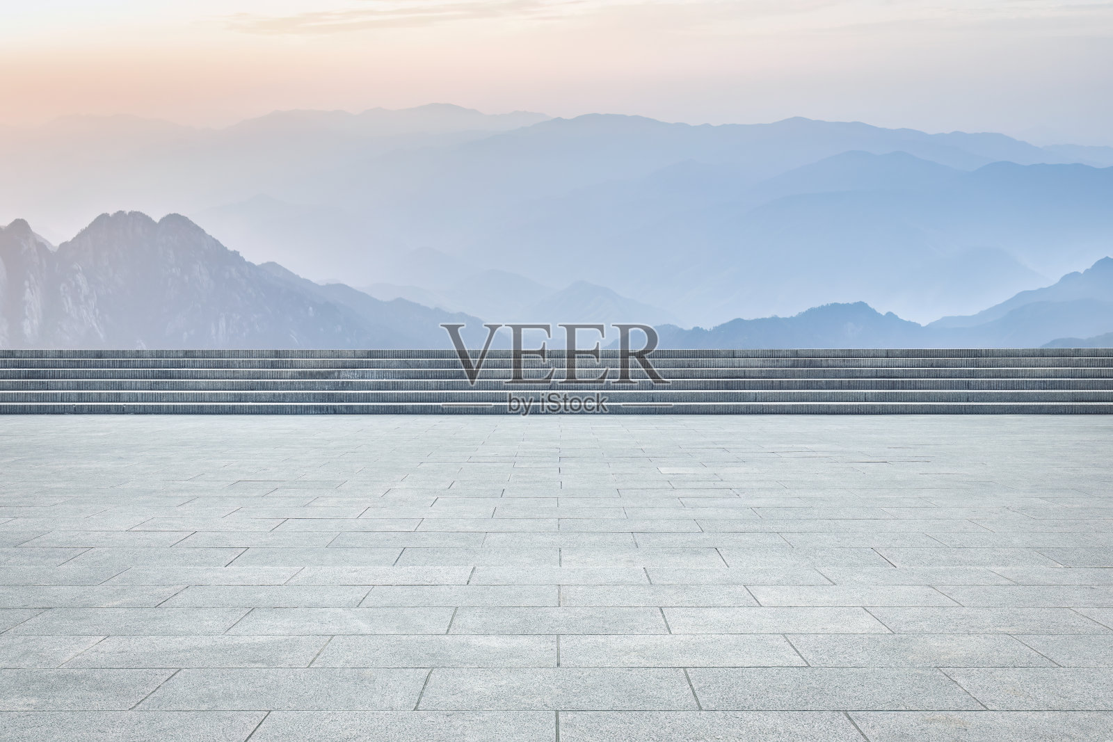 阳光明媚的白天，空旷的广场人行道和山景照片摄影图片