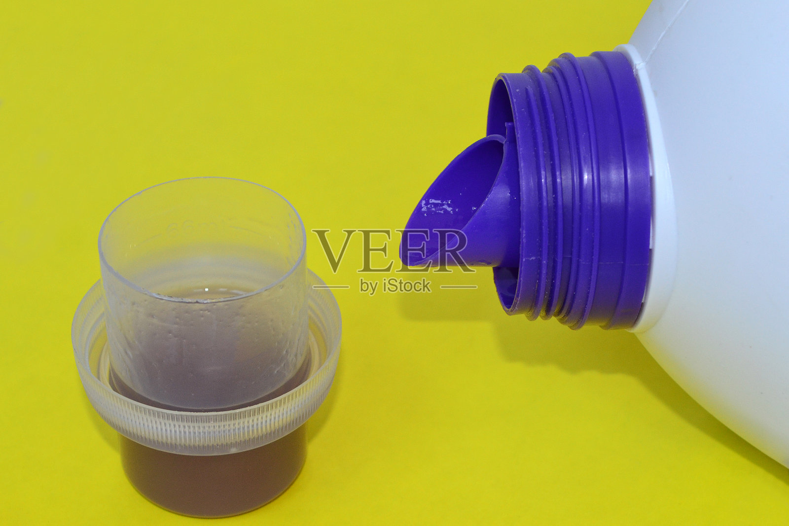 在黄色的背景上有一瓶粉末的瓶盖照片摄影图片