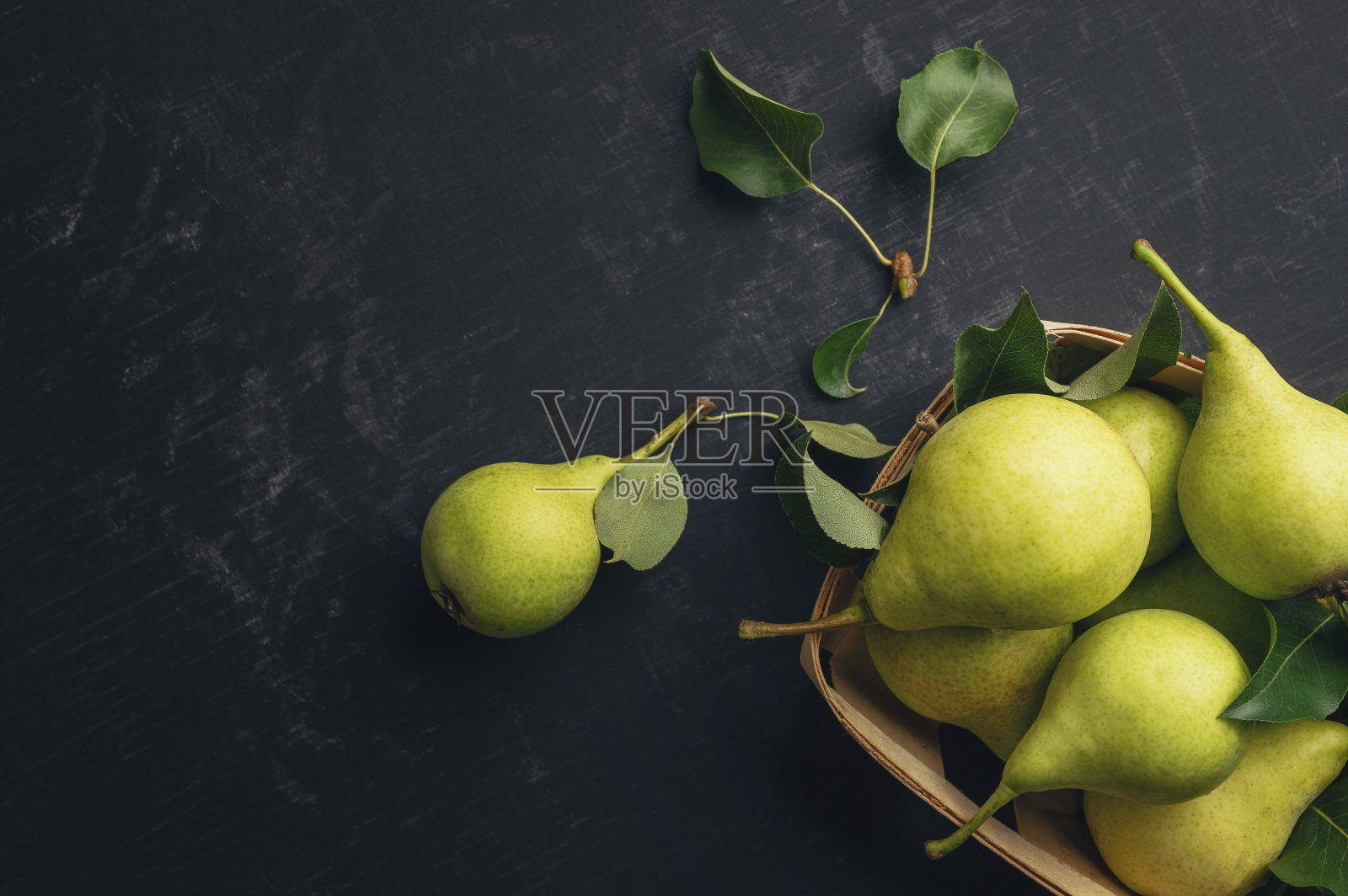 黑黑的桌子上放着新鲜的梨。木制背景上的梨子。水果的收成。秋天的静物。前视图。平的。Copyspace照片摄影图片