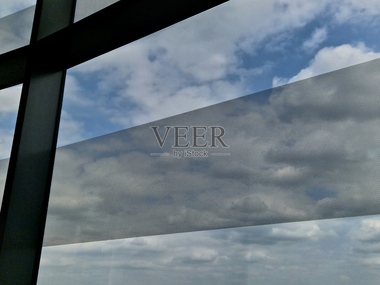 用于房屋或公司办公室窗户上的自粘穿孔贴纸。透明和阴影功能。立面结构的设计元素和带有印刷的广告横幅照片摄影图片