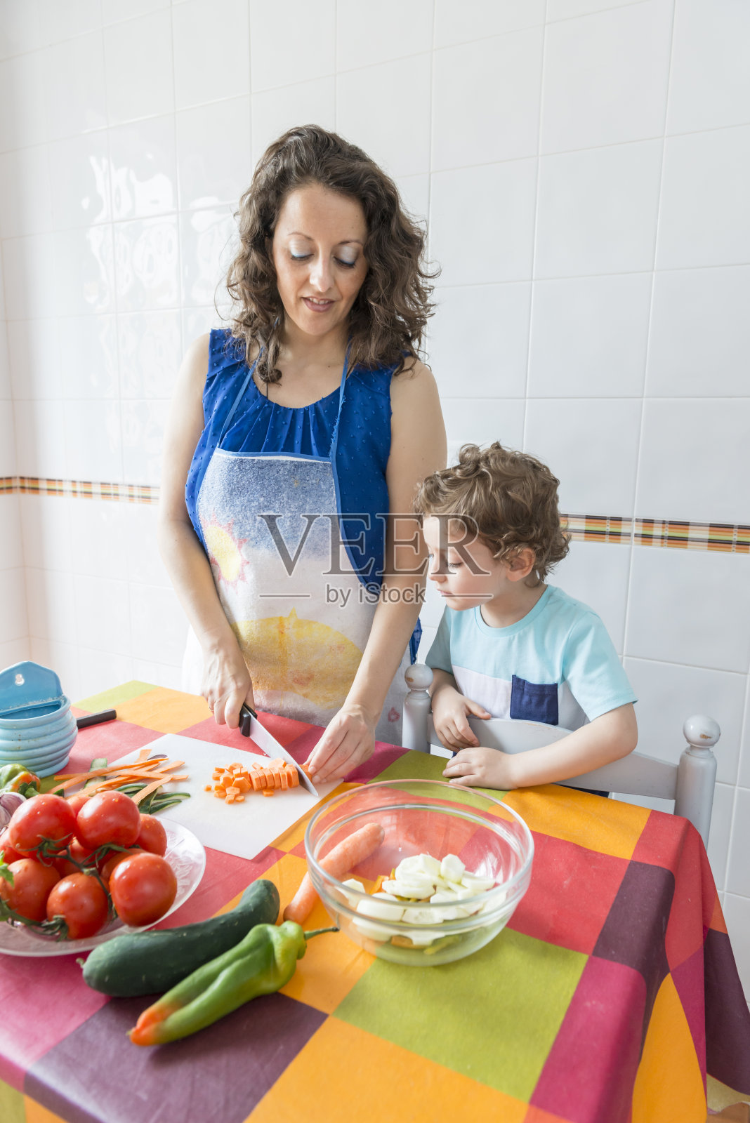 一个女人和一个男孩一起做饭。照片摄影图片