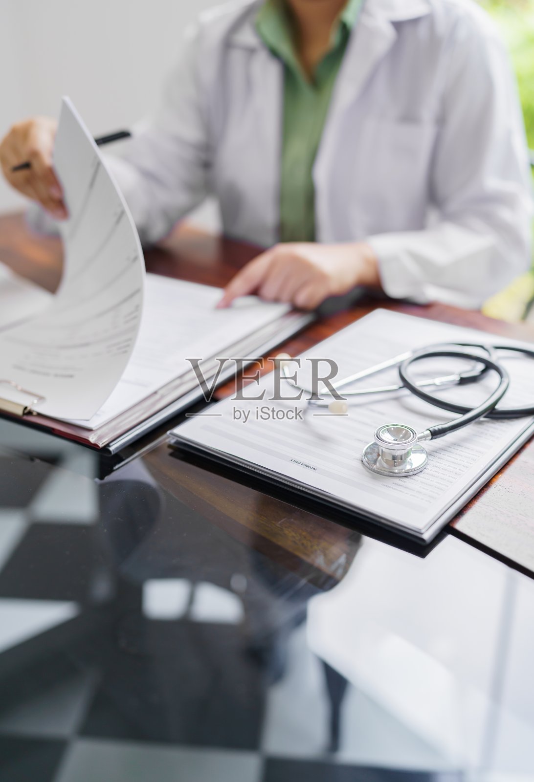 穿着白色制服长袍大衣的专业医生接见咨询病人。照片摄影图片