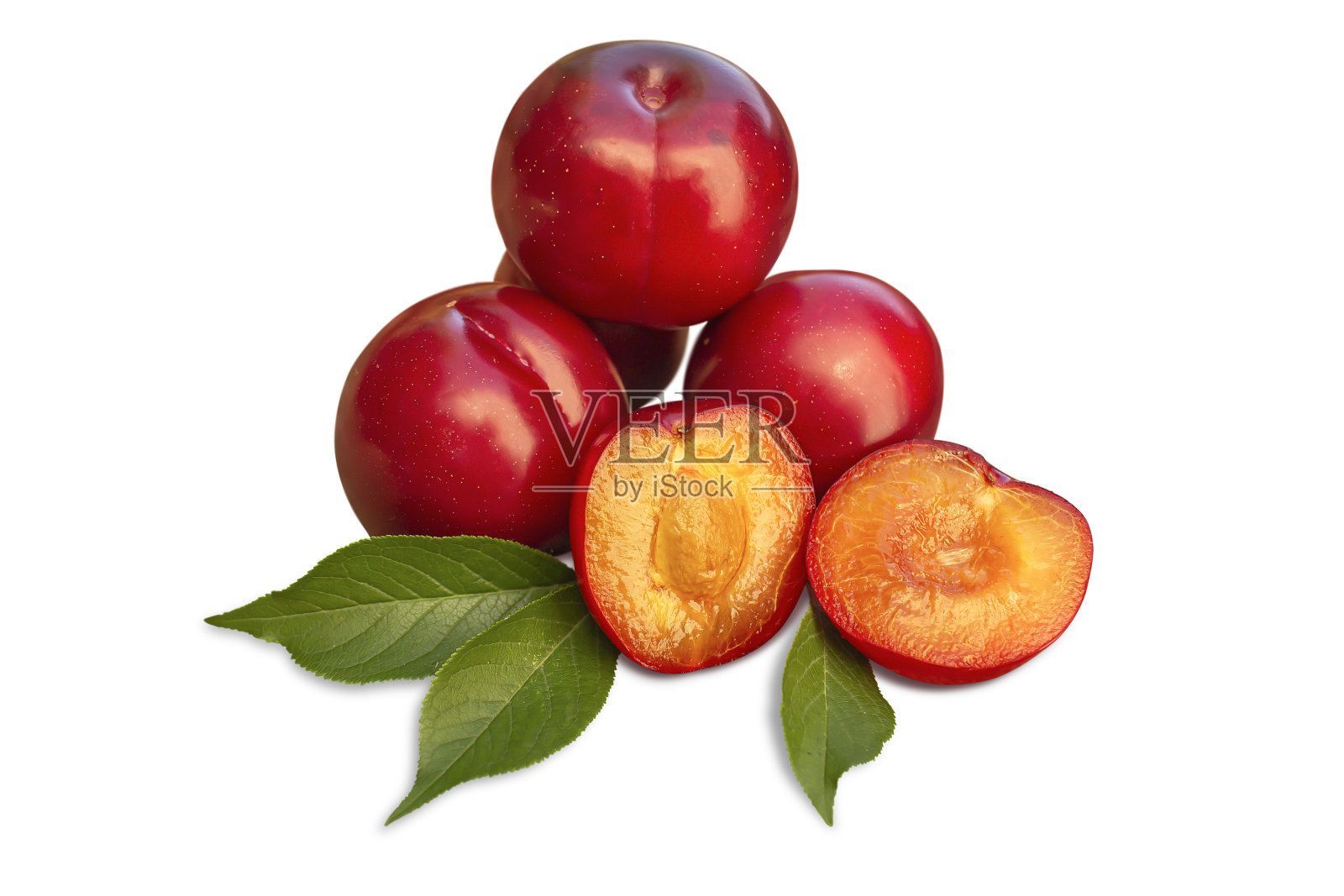 成熟的整个李子，半李子和绿叶。照片摄影图片