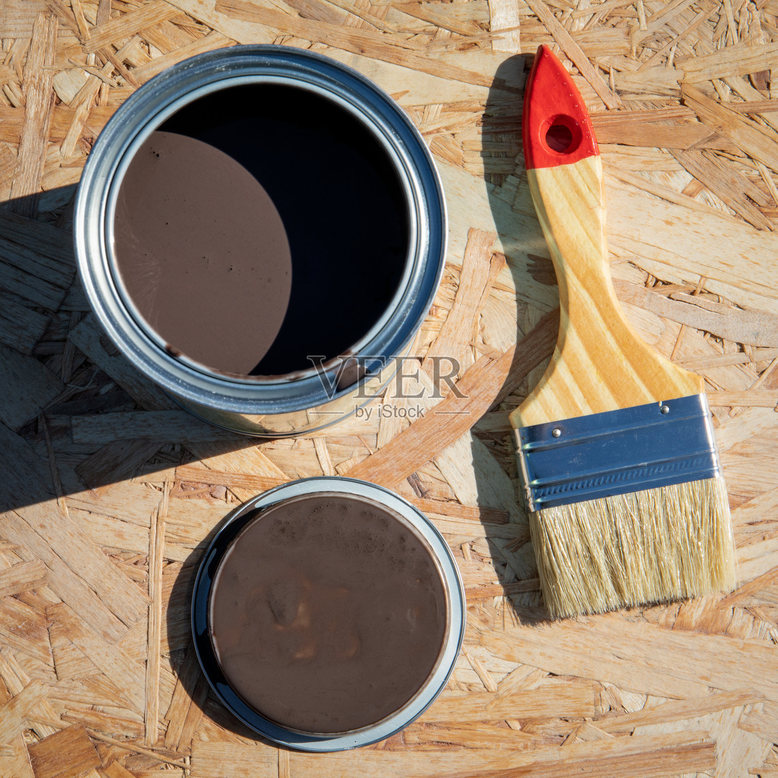 在刨花板上准备维修的画笔和油漆照片摄影图片