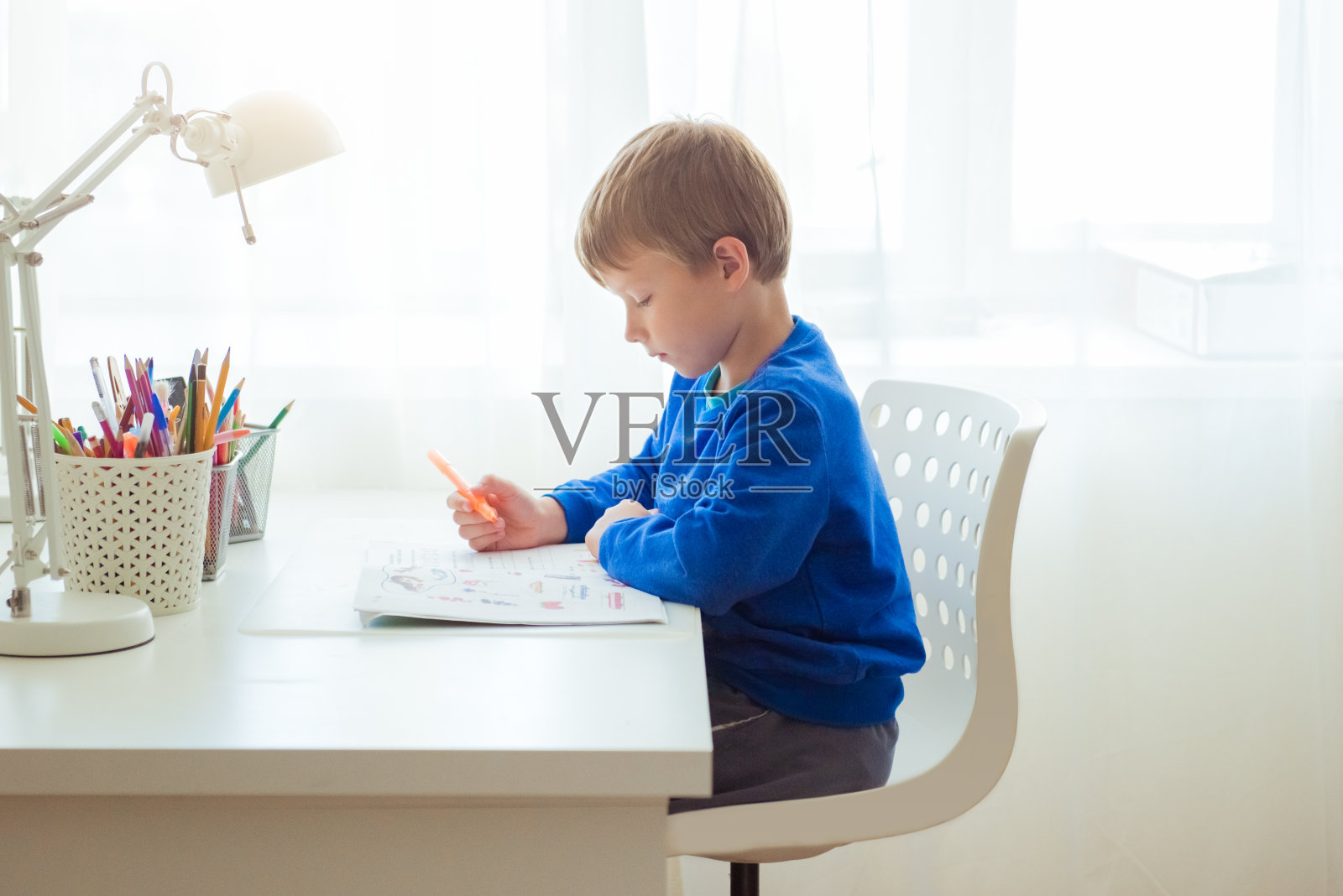 可爱的小孩学龄前男孩在早上上学前在家做作业。儿童英语学习照片摄影图片