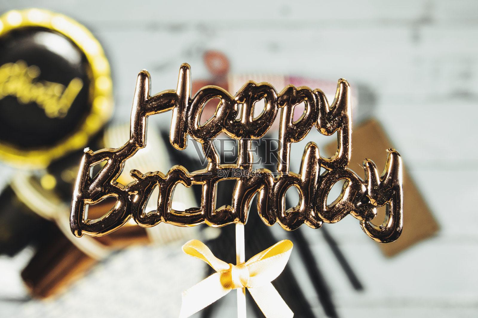 生日快乐概念，一次性杯子和盘子，吸管，巧克力和果冻糖在木桌上照片摄影图片