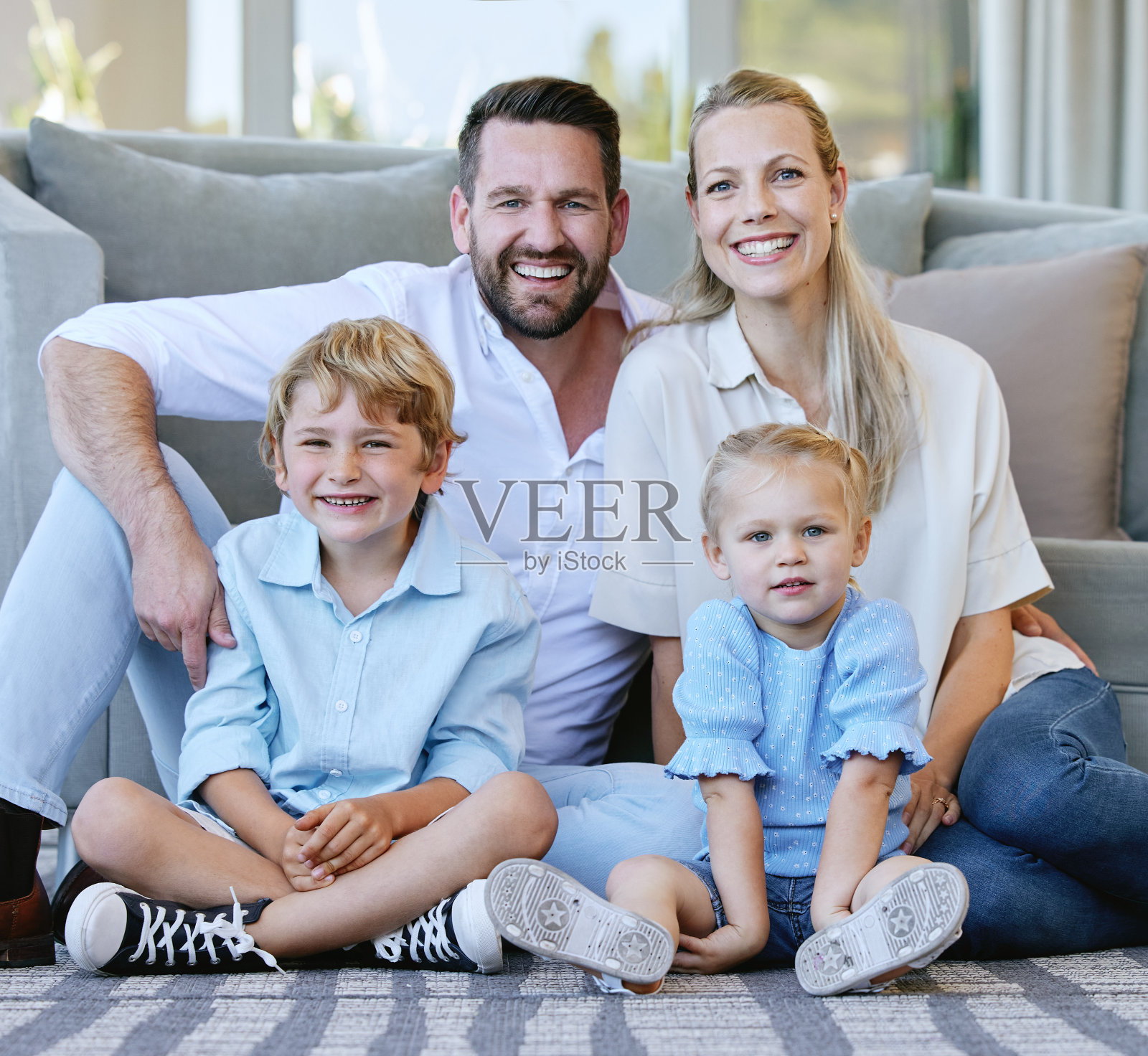 充满爱意的中年夫妇和孩子坐在家中客厅里的全身像照片摄影图片