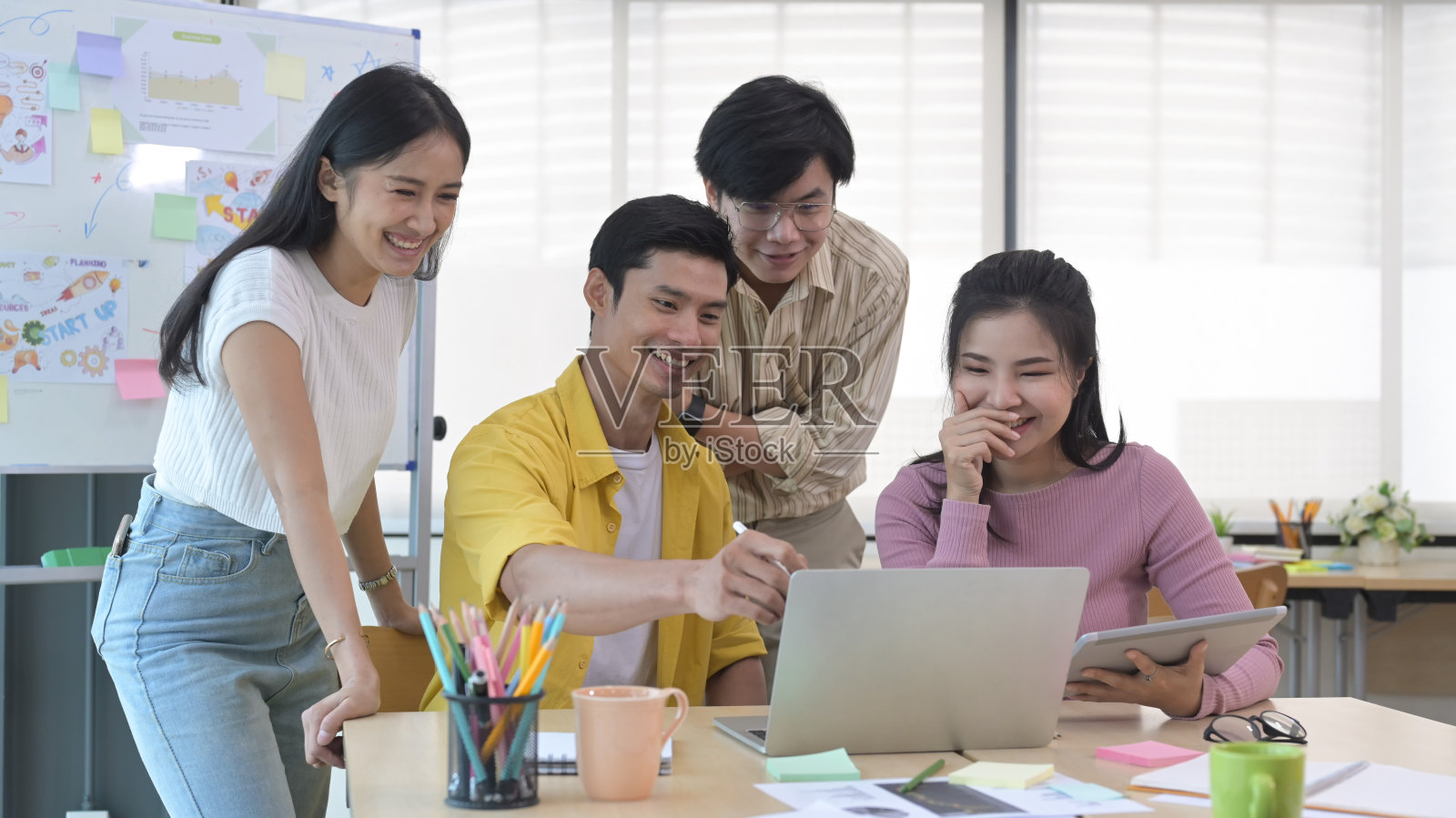 感兴趣的快乐的年轻员工听着男组长在会议上解释新的在线项目。照片摄影图片