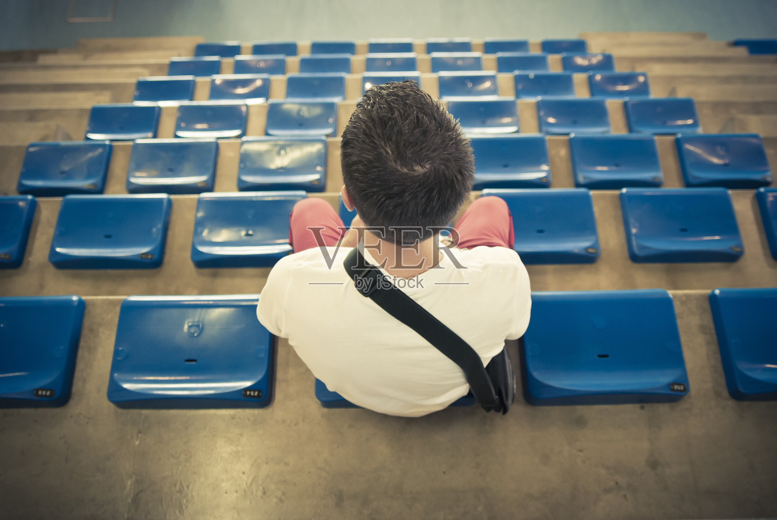 坐在体育场看台上看比赛的观众照片摄影图片