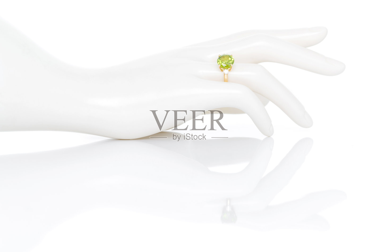 橄榄石和钻石宝石或宝石戒指上的塑料人体模型女性的手。收藏天然宝石配件。影棚拍摄照片摄影图片