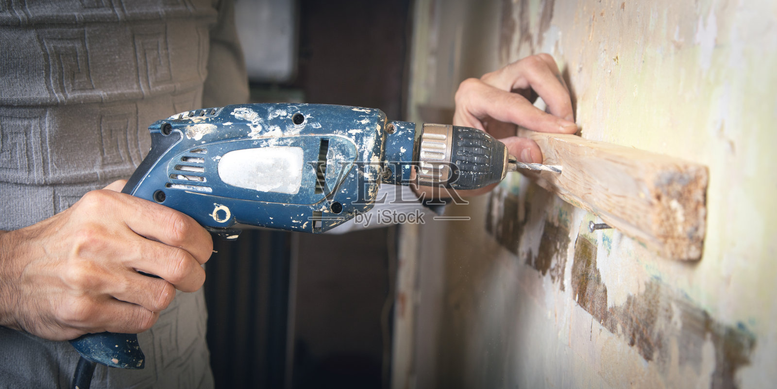 男人拿着钻头。做房屋装修照片摄影图片