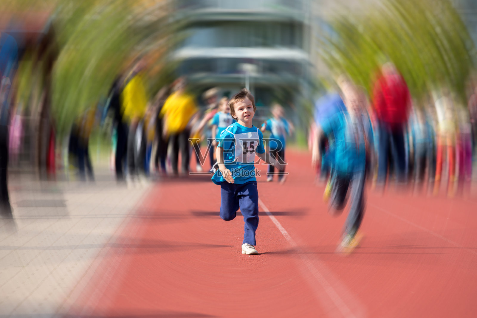幼小的学龄前儿童，在马拉松比赛的跑道上奔跑，径向模糊运动照片摄影图片