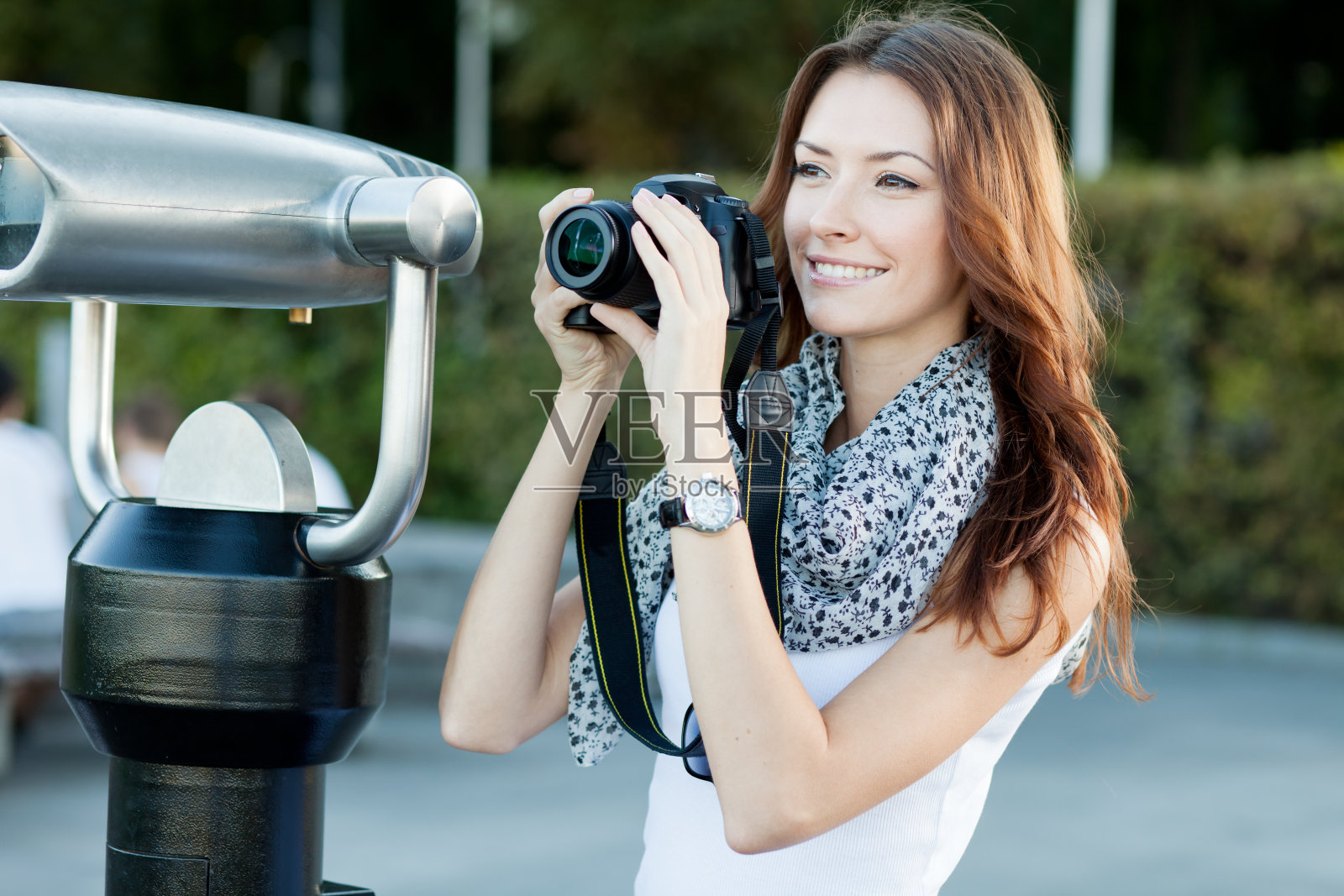 年轻的女游客在望远镜附近拍照照片摄影图片