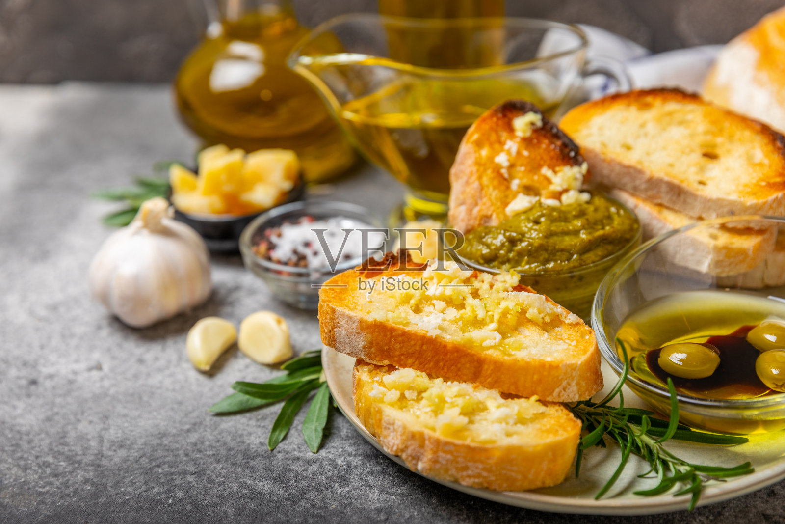 ciabatta，一碗橄榄油，配上橄榄、香草、香料、大蒜、香蒜酱、帕尔马干酪和ciabatta面包。健康食品理念，美味。地中海厨房。副本的空间。照片摄影图片