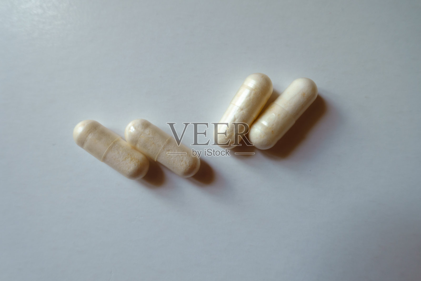 两对浅米色胶囊益生菌膳食补充剂从上面照片摄影图片