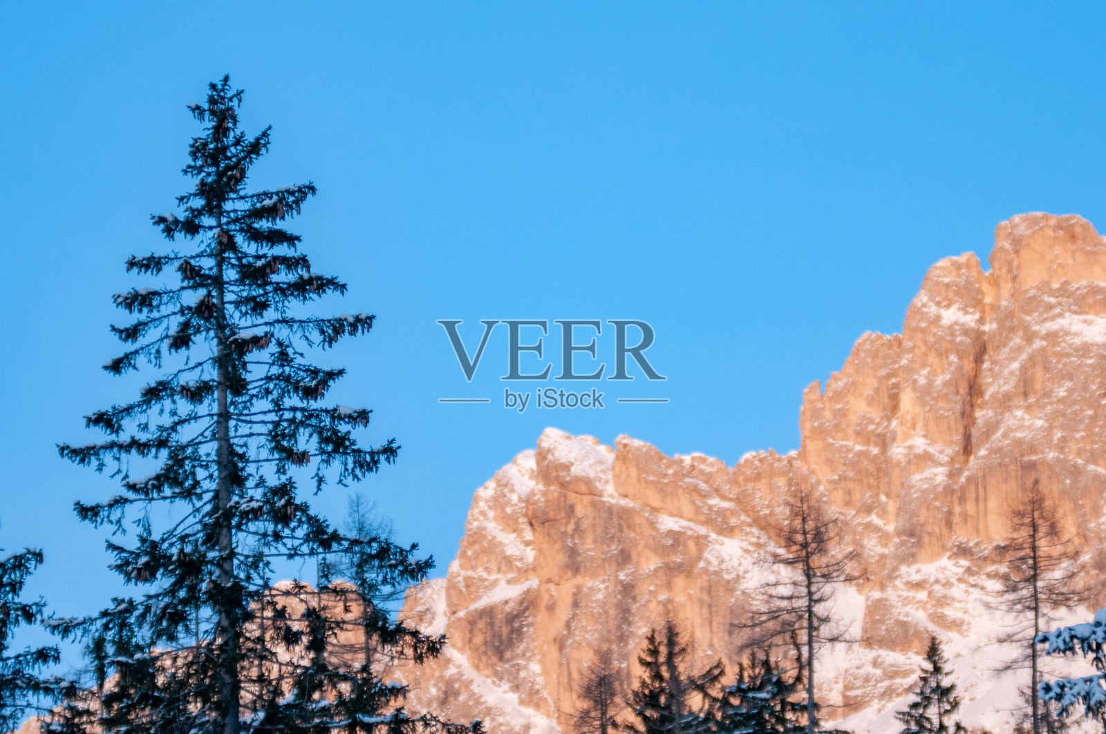 意大利的多洛米蒂山脉在冬天日落时部分被雪覆盖照片摄影图片