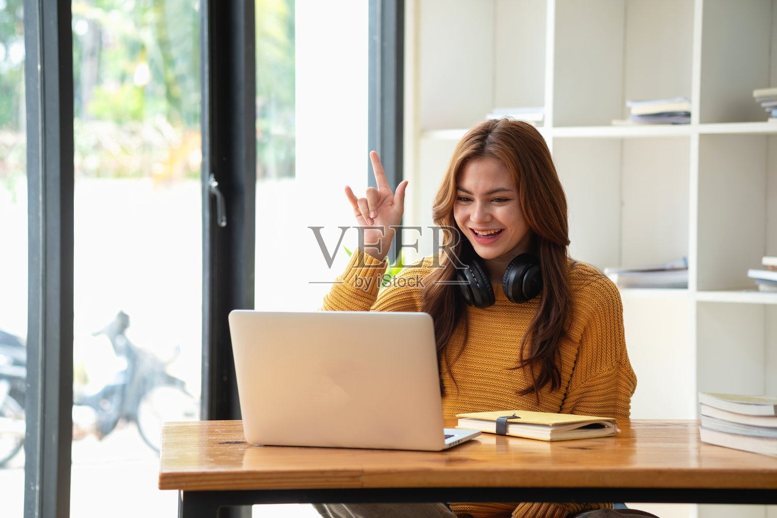 快乐拉丁女大学生观看远程在线学习课程，远程大学网络研讨会或在笔记本电脑上进行视频通话，并使用笔记本电脑在家或校园进行虚拟会议研讨会照片摄影图片