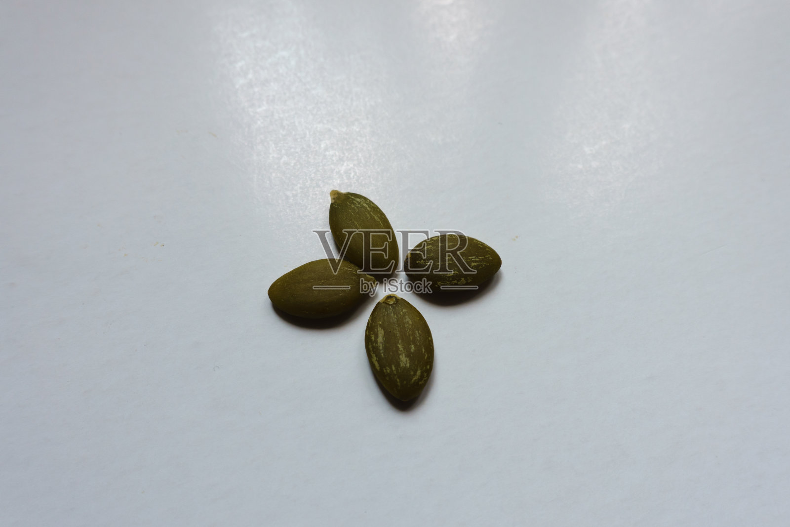 近距离观察四个带壳的南瓜籽照片摄影图片