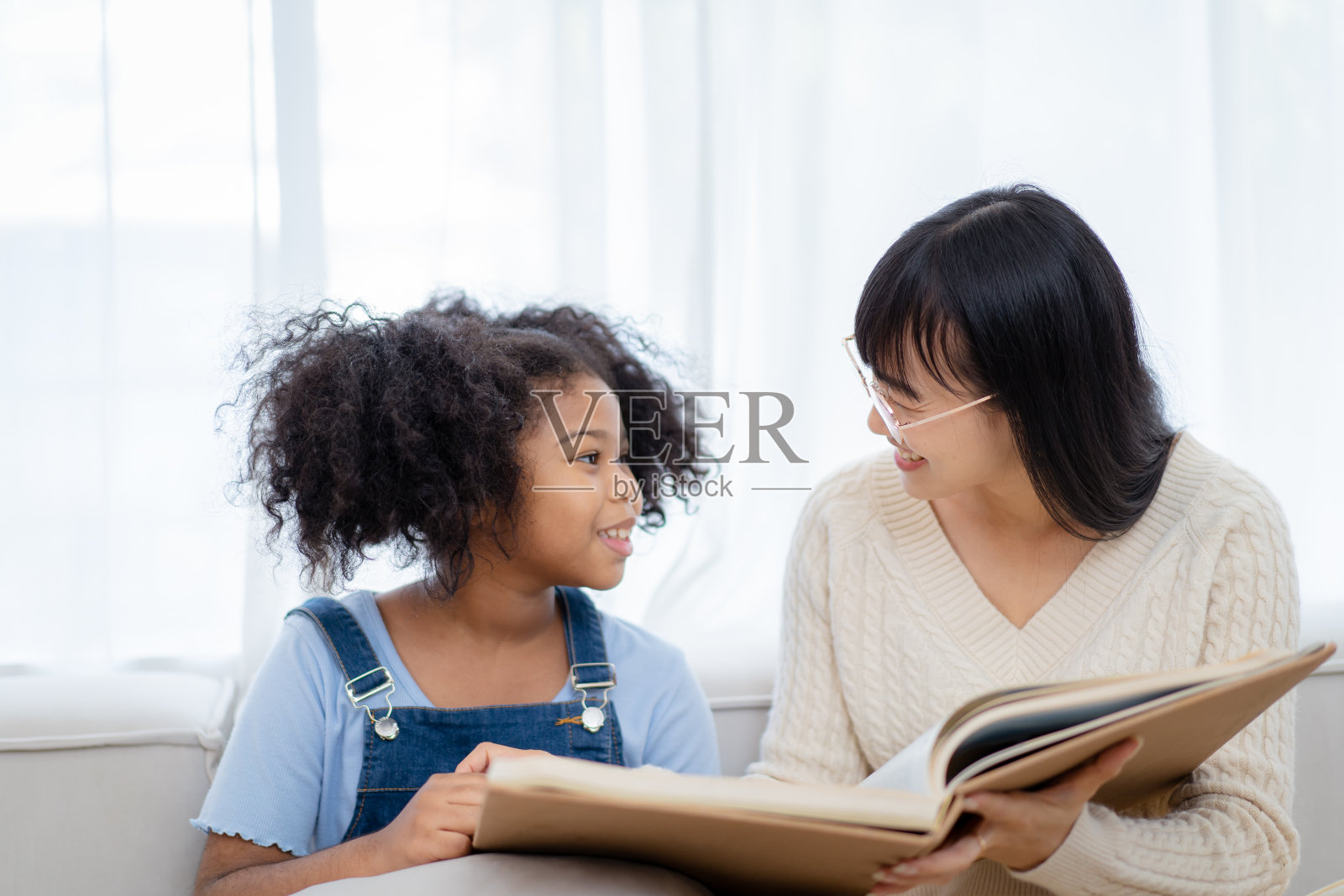 女人和养女在客厅里。照片摄影图片