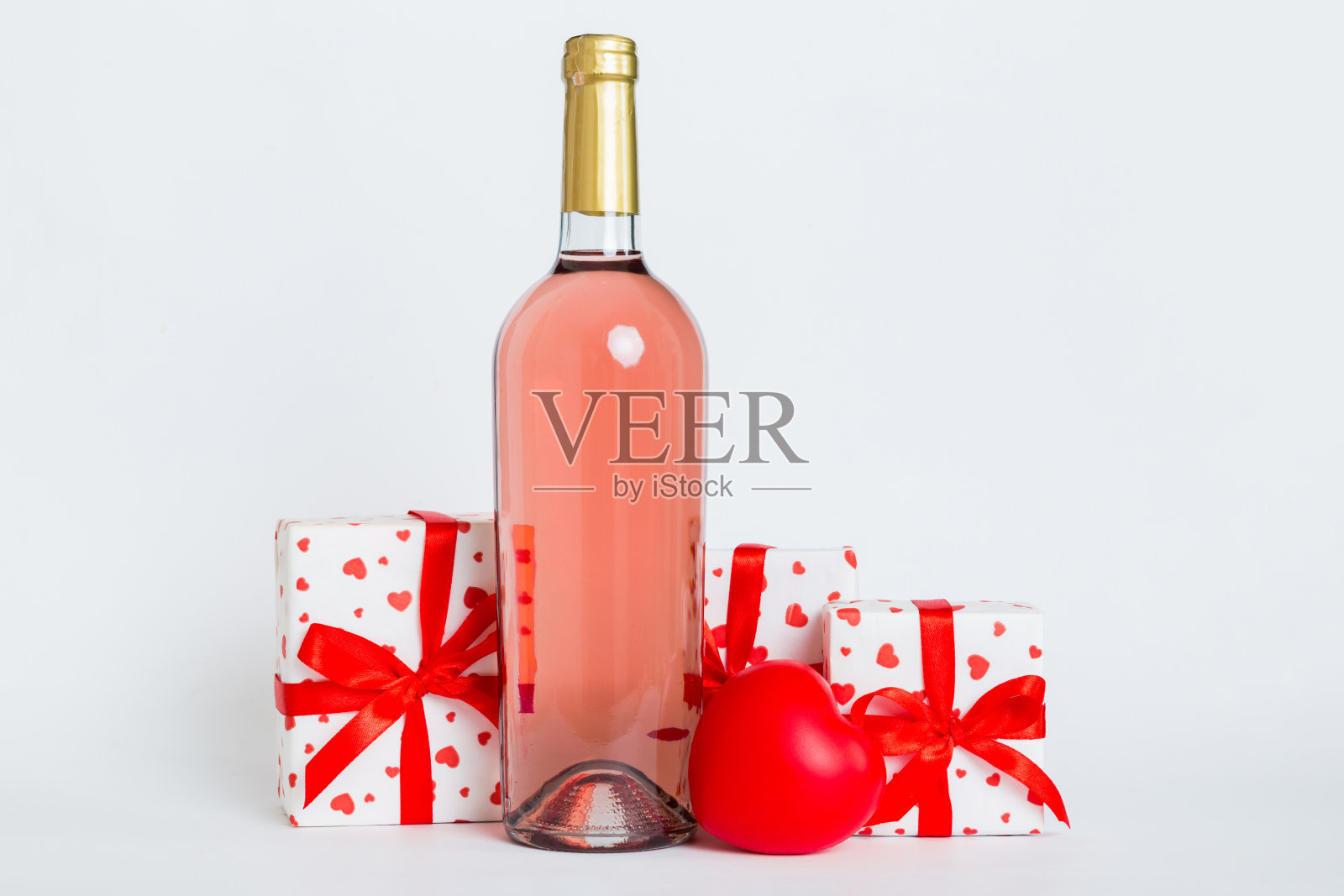 一瓶酒在彩色背景情人节与礼盒。带有当前框透视图的心形，带有复制空间照片摄影图片