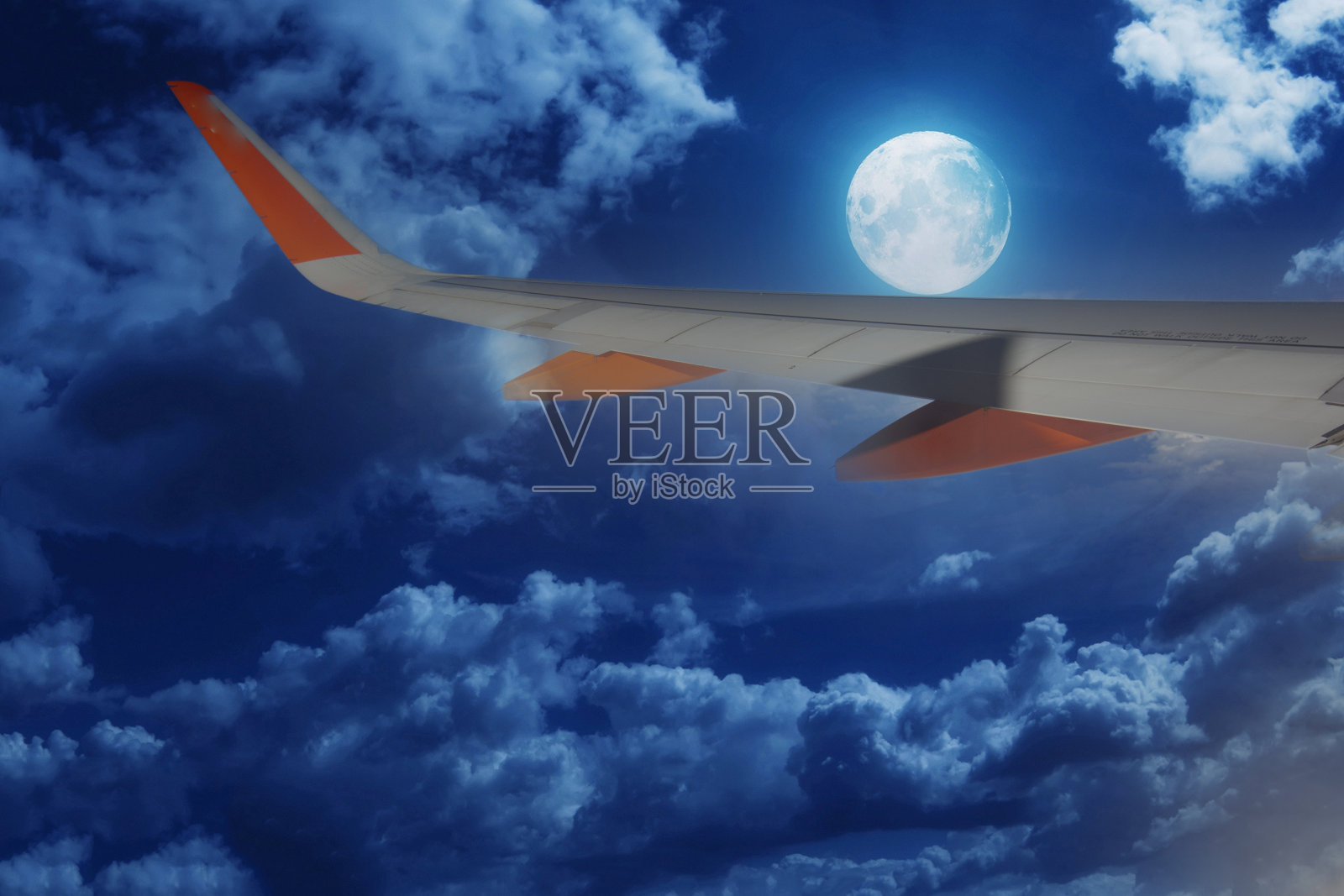 飞机在一个有月亮的晴朗夜晚飞行照片摄影图片