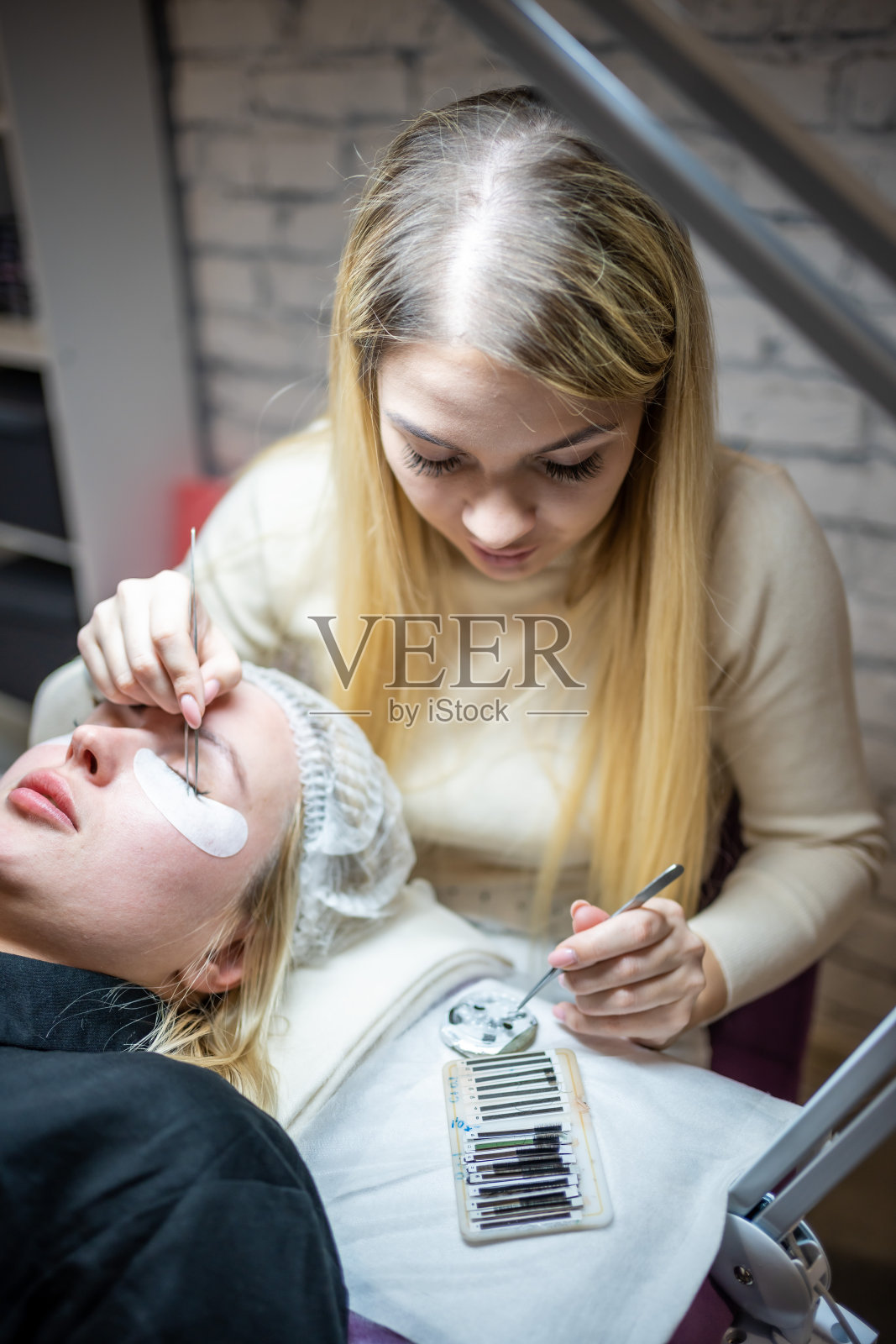 在美容院做睫毛延长手术。睫毛密切起来。概念spa睫毛照片摄影图片