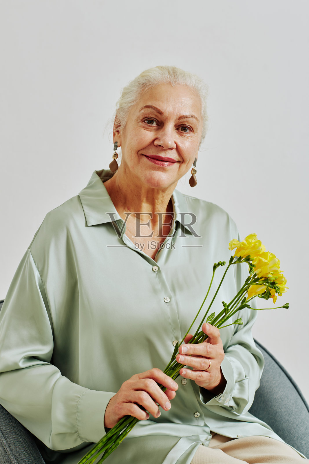 手持鲜花的老年妇女的最小肖像照片摄影图片
