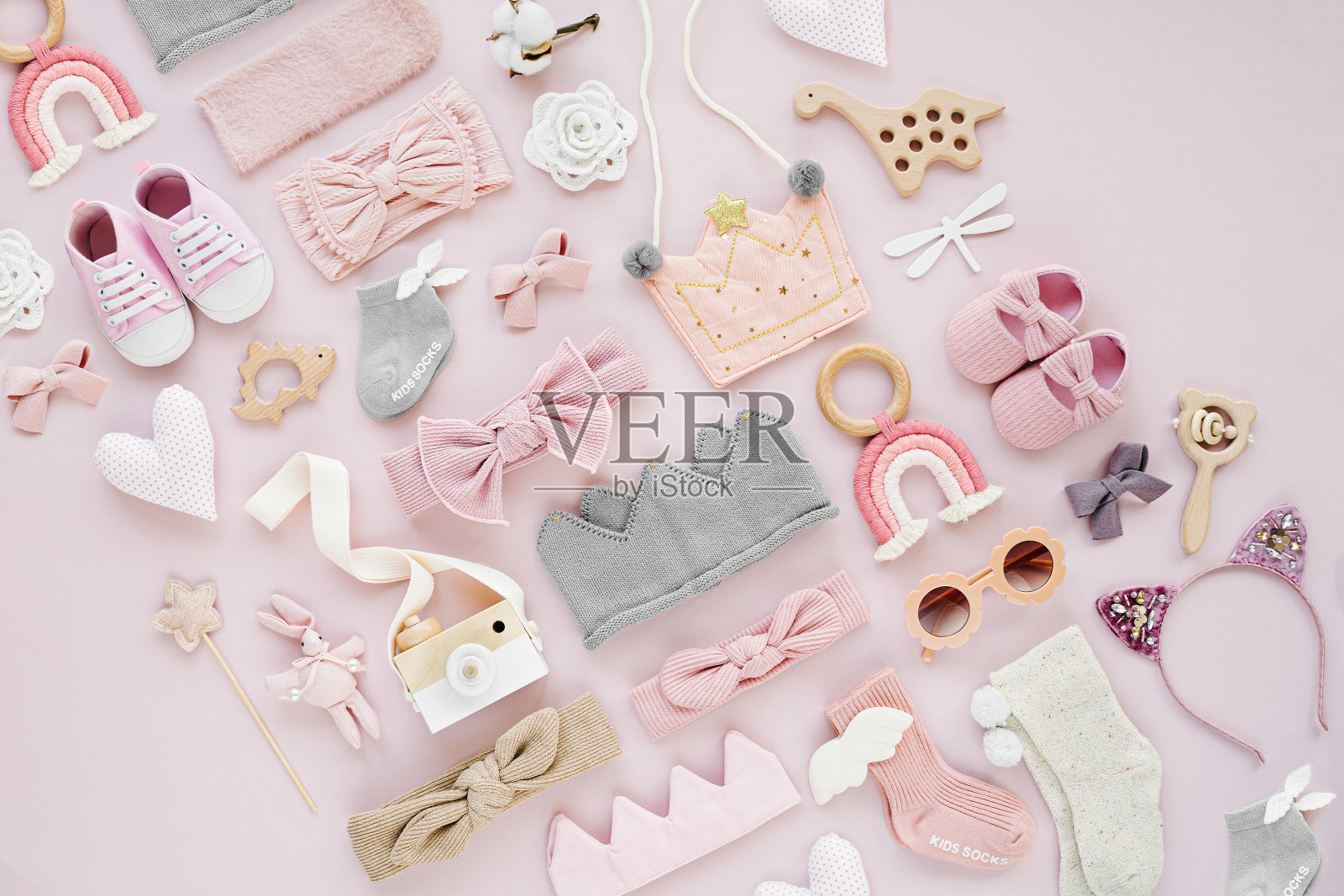 一套女婴配件在粉红色的背景。各种头带、发弓、玩具、小鞋、袜子。时尚的孩子的东西和配件。平铺，俯视图照片摄影图片
