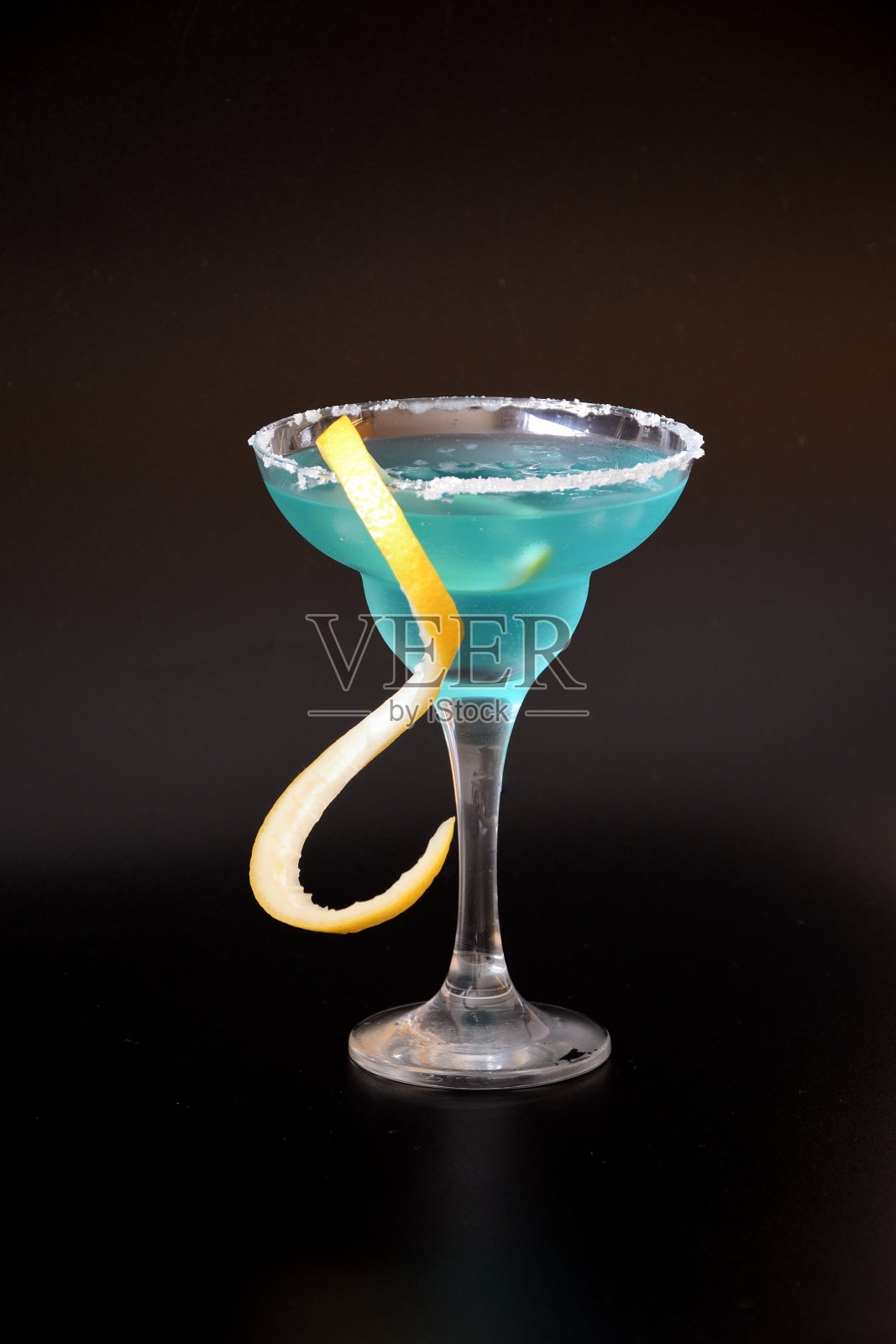 高杯的代基里利口酒，柠檬皮和糖边在黑色的背景。照片摄影图片