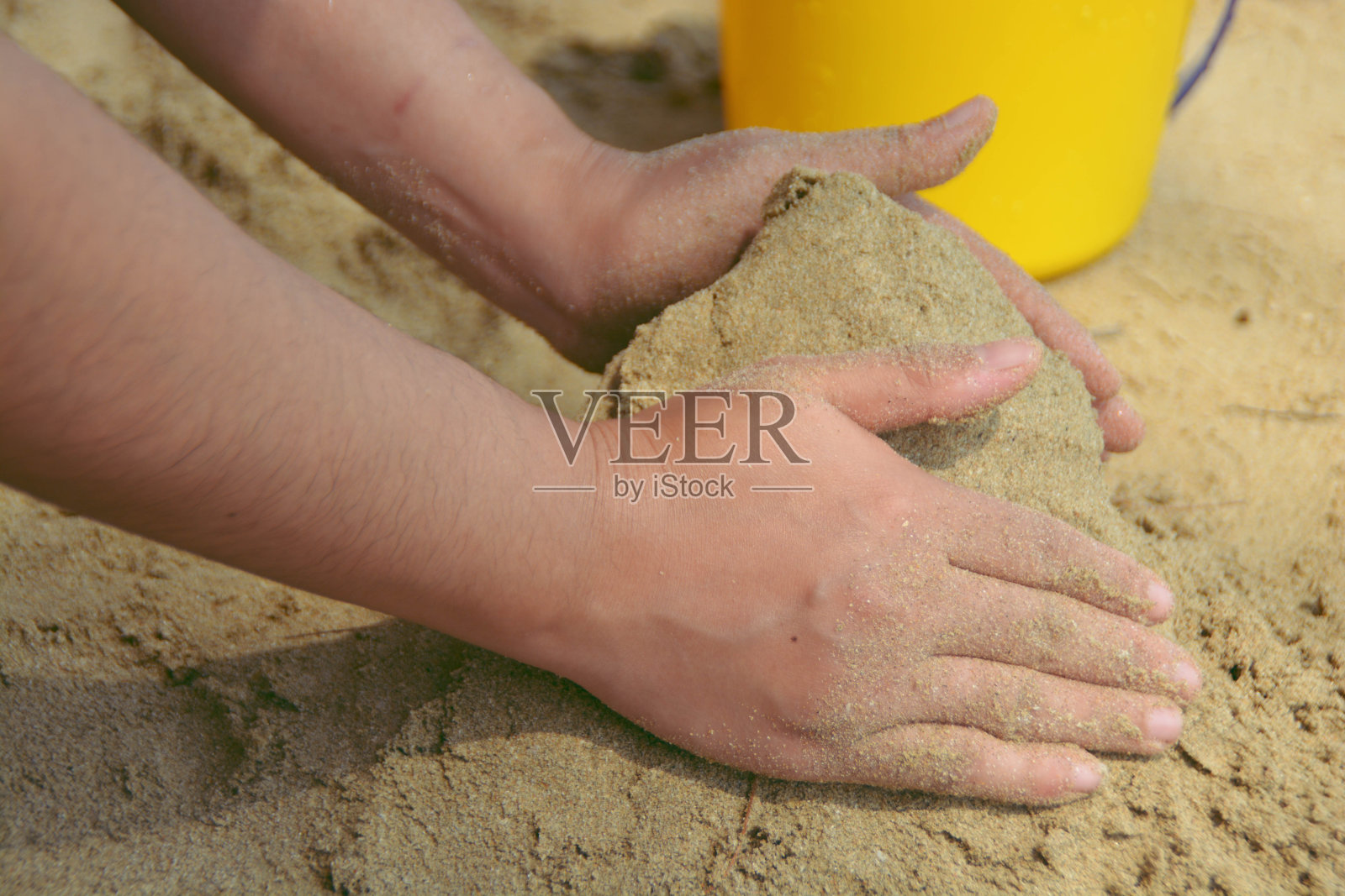 有人在沙滩上手工建造沙堡。照片摄影图片