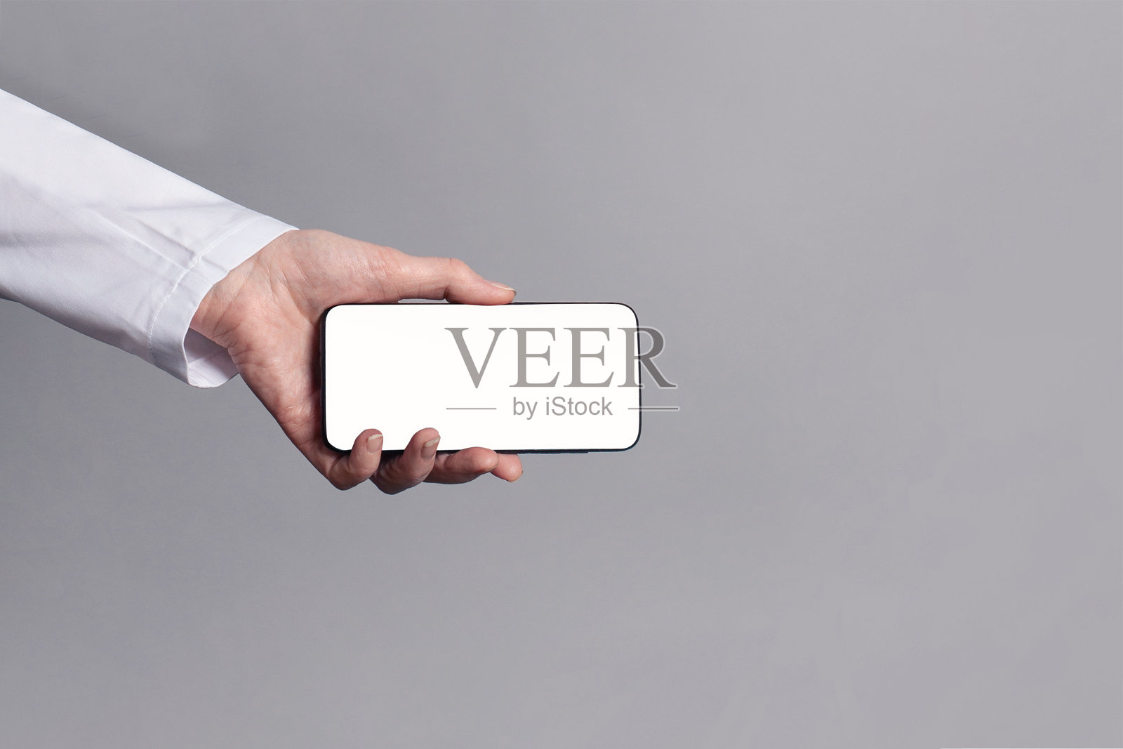 医生手医制服显示空白屏幕手机在蓝色背景照片摄影图片