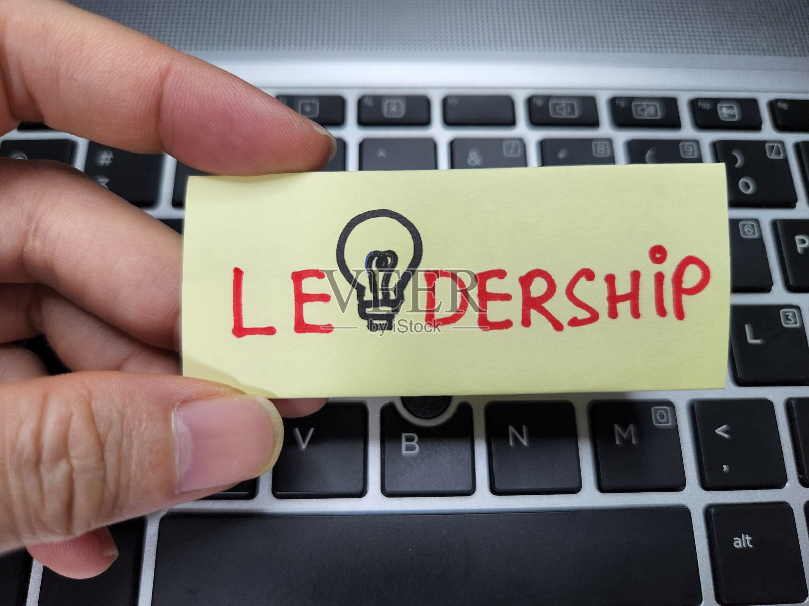 拿着一张写着“领导”的便利贴照片摄影图片