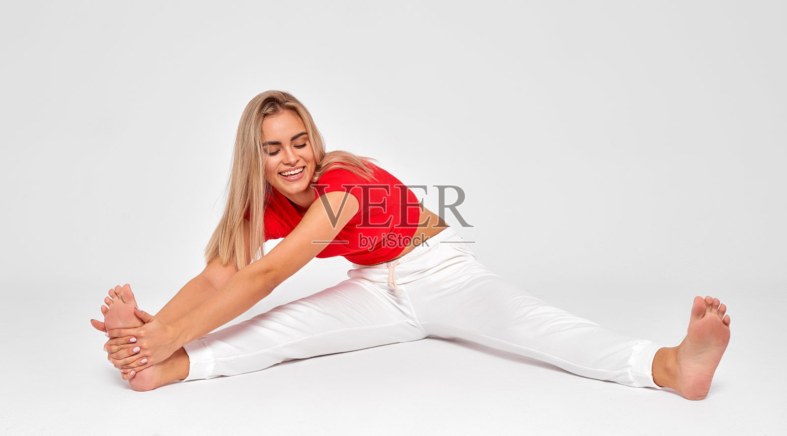 迷人的金发女子在灰色背景下做运动照片摄影图片