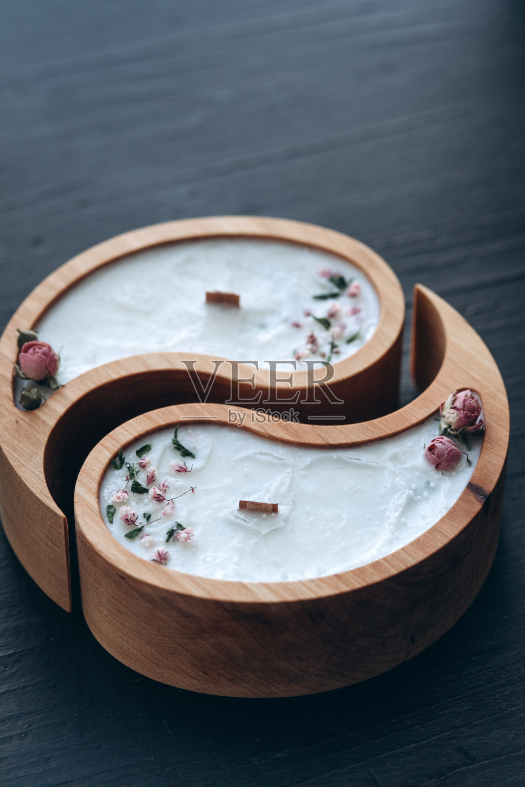 手工芳香概念。木制阴阳形状的大豆蜡烛和天然蜡味的干花特写照片摄影图片