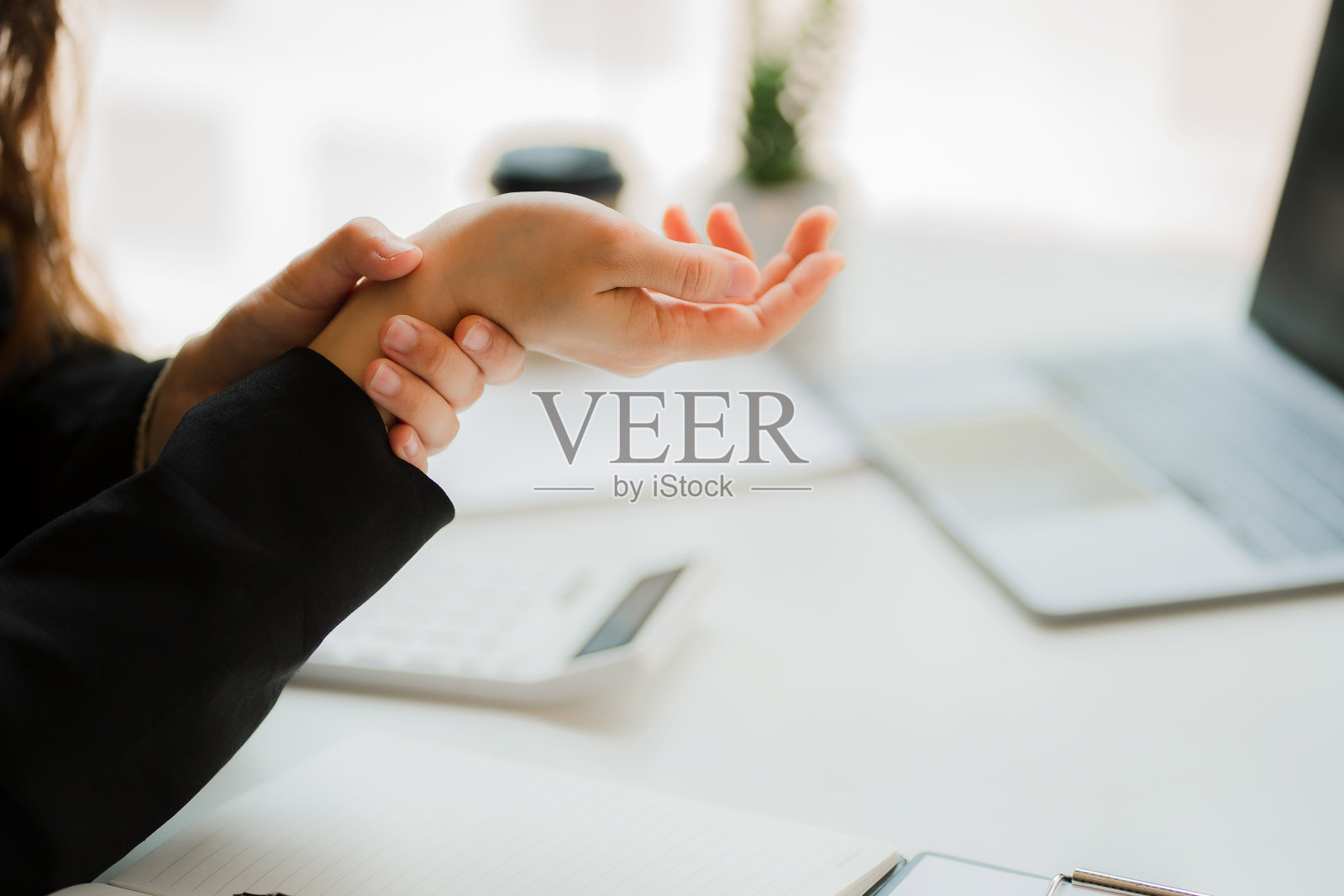 女孩因在笔记本电脑上打字而手腕疼痛照片摄影图片