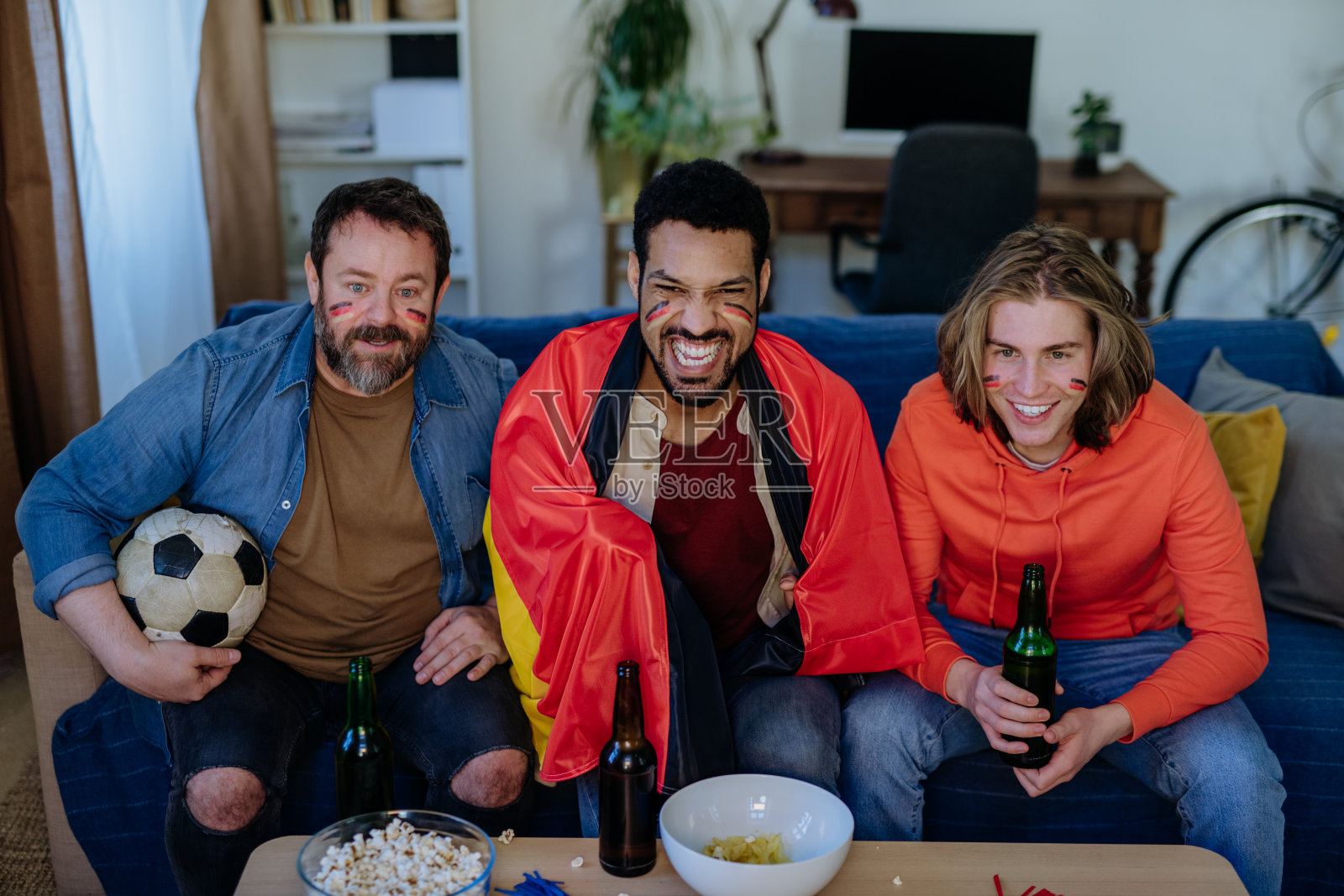 快乐的德国球迷朋友们在家里观看比赛并庆祝照片摄影图片
