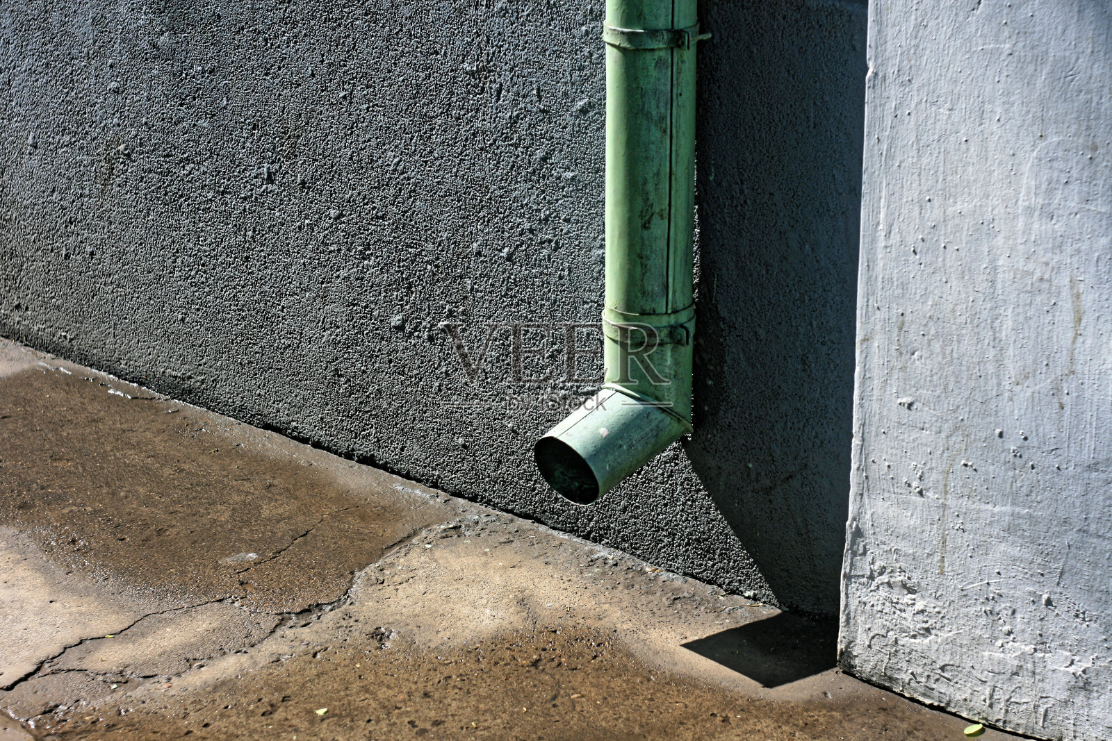 灰色的墙和绿色的排水管照片摄影图片