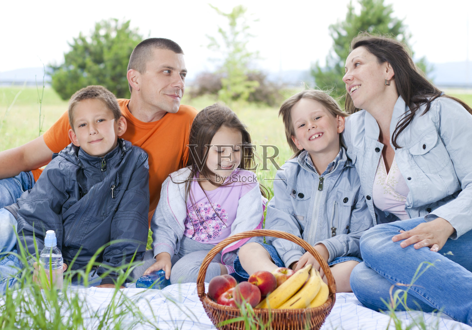 快乐的五口之家在花园野餐照片摄影图片