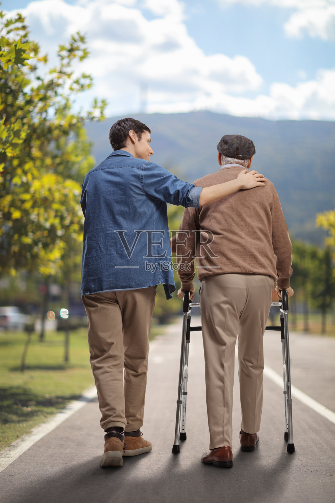 一个年轻人在户外帮一个老人扶助车照片摄影图片