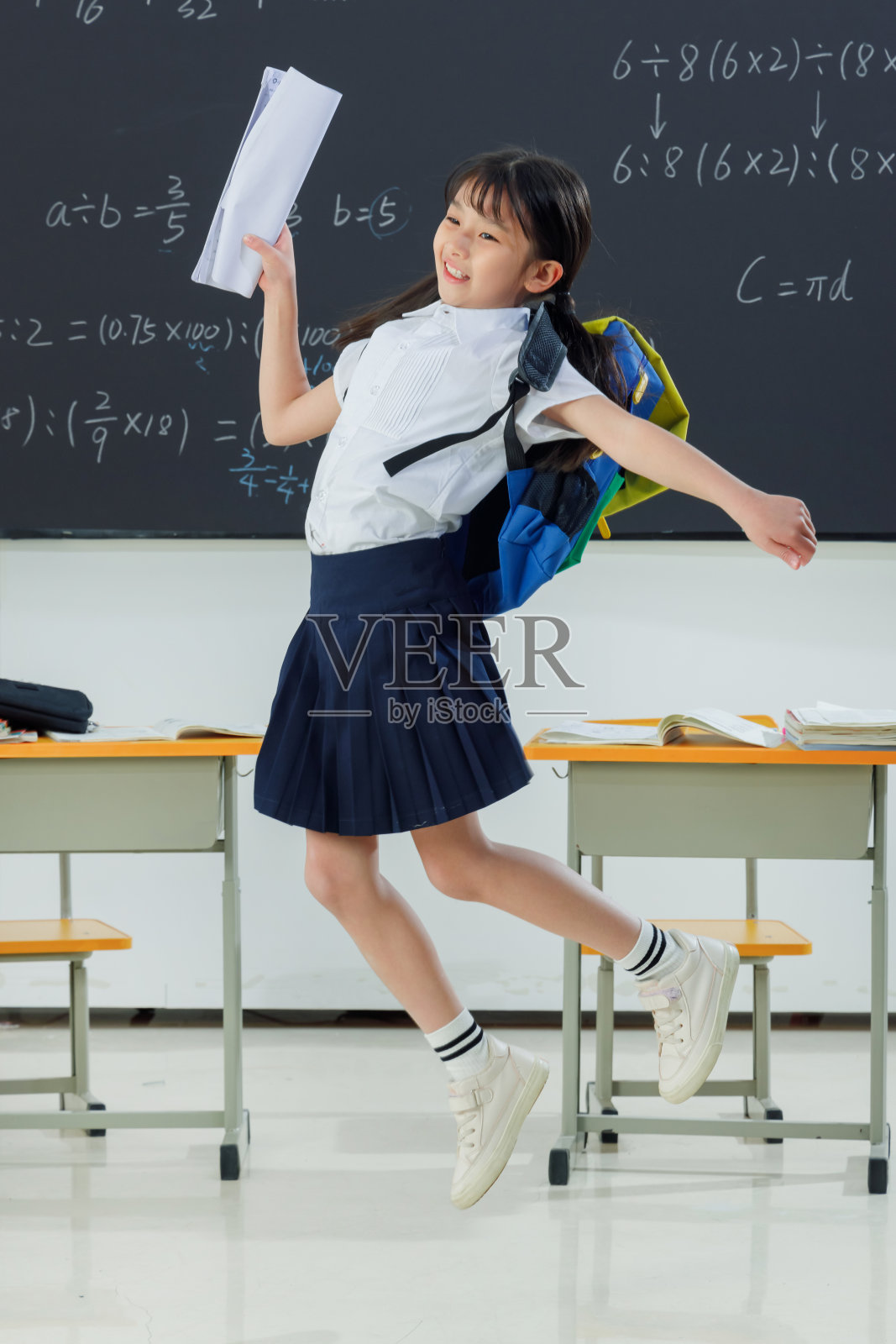 快乐的小学女生在教室里欢呼跳跃照片摄影图片