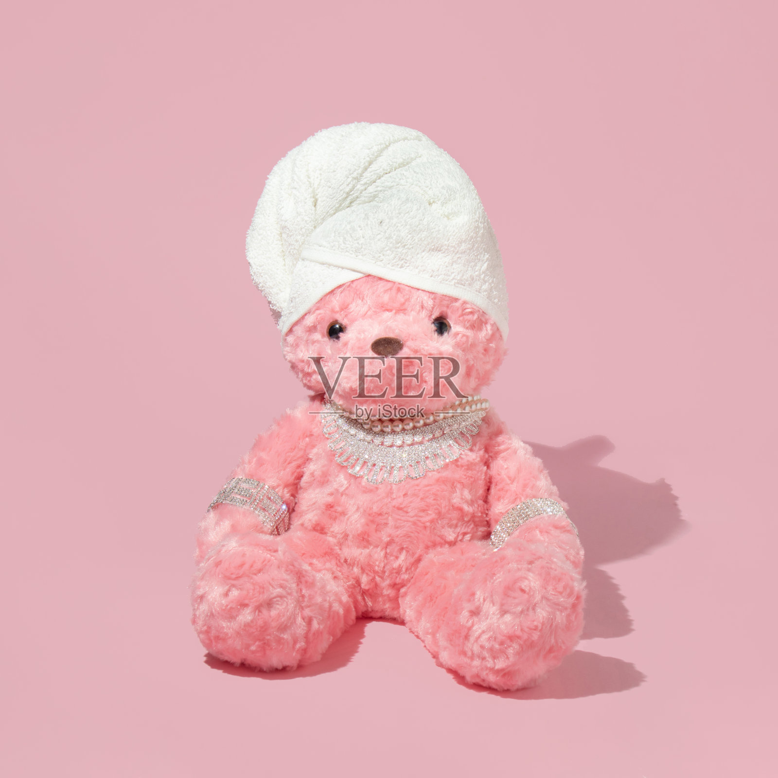 创意布局与粉红色的泰迪熊与毛巾头巾和奢侈品珠宝在柔和的粉红色背景。80或90年代复古时尚或生活方式的概念。美容新潮沙龙的想法。照片摄影图片