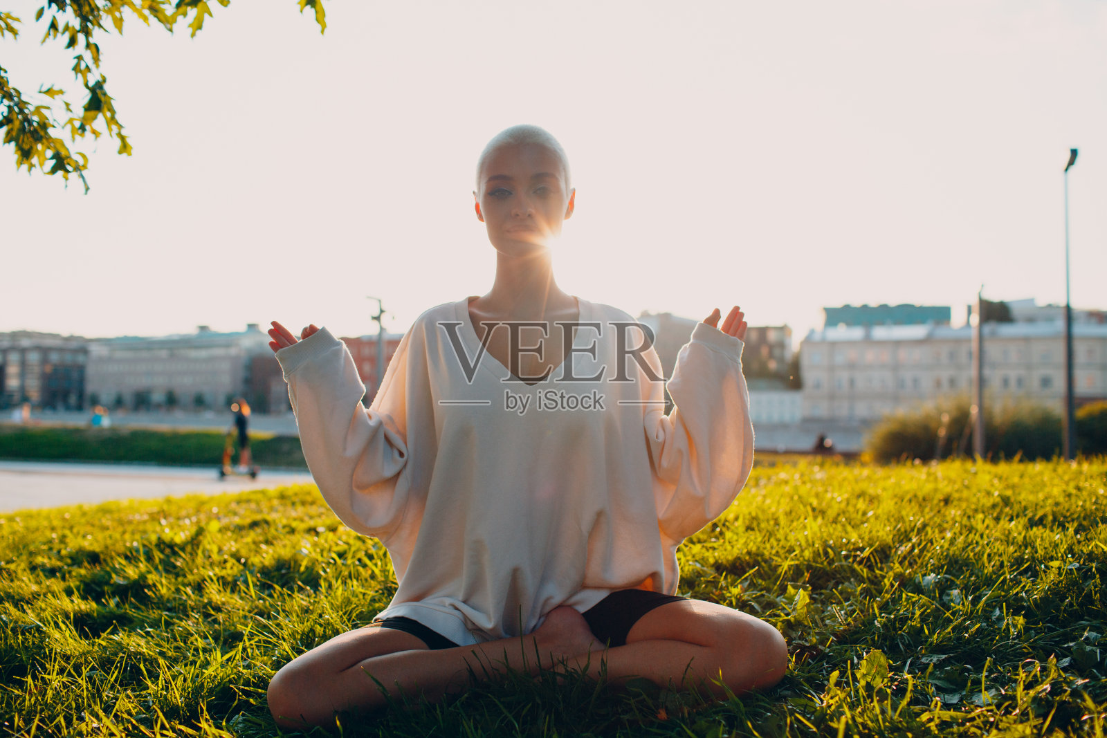 年轻女子在公园里做瑜伽莲花式照片摄影图片