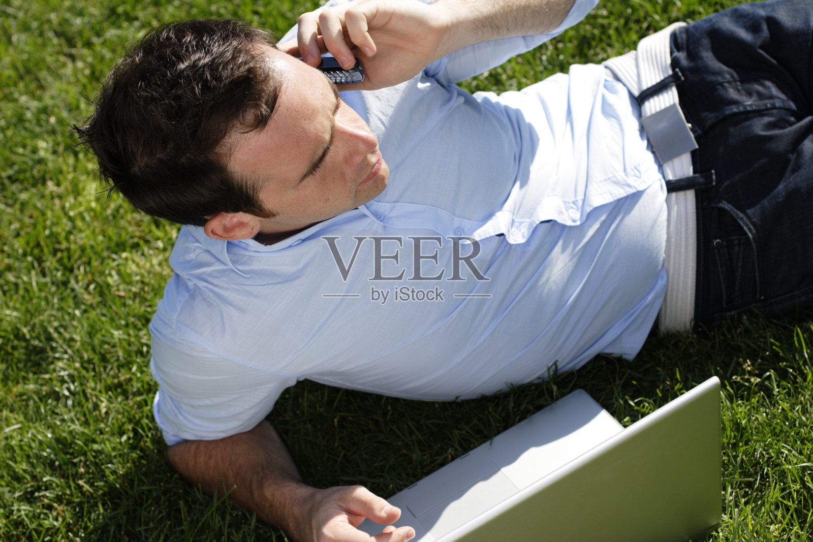 用手提电脑打手机的男人照片摄影图片